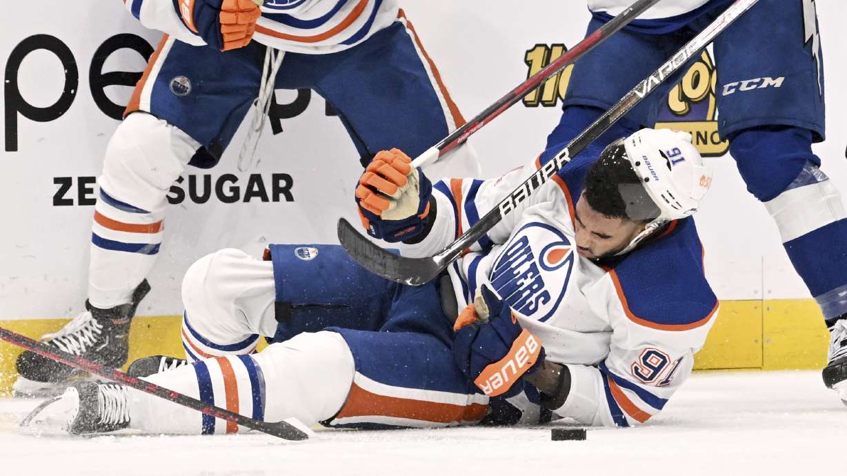 Edmonton Oilers left wing Evander Kane (91) is knocked to the ice during the second period of an NHL hockey game against the Tampa Bay Lightning Tuesday, Nov. 8, 2022, in Tampa, Fla. Kane would leave the ice after being cut on the play.
