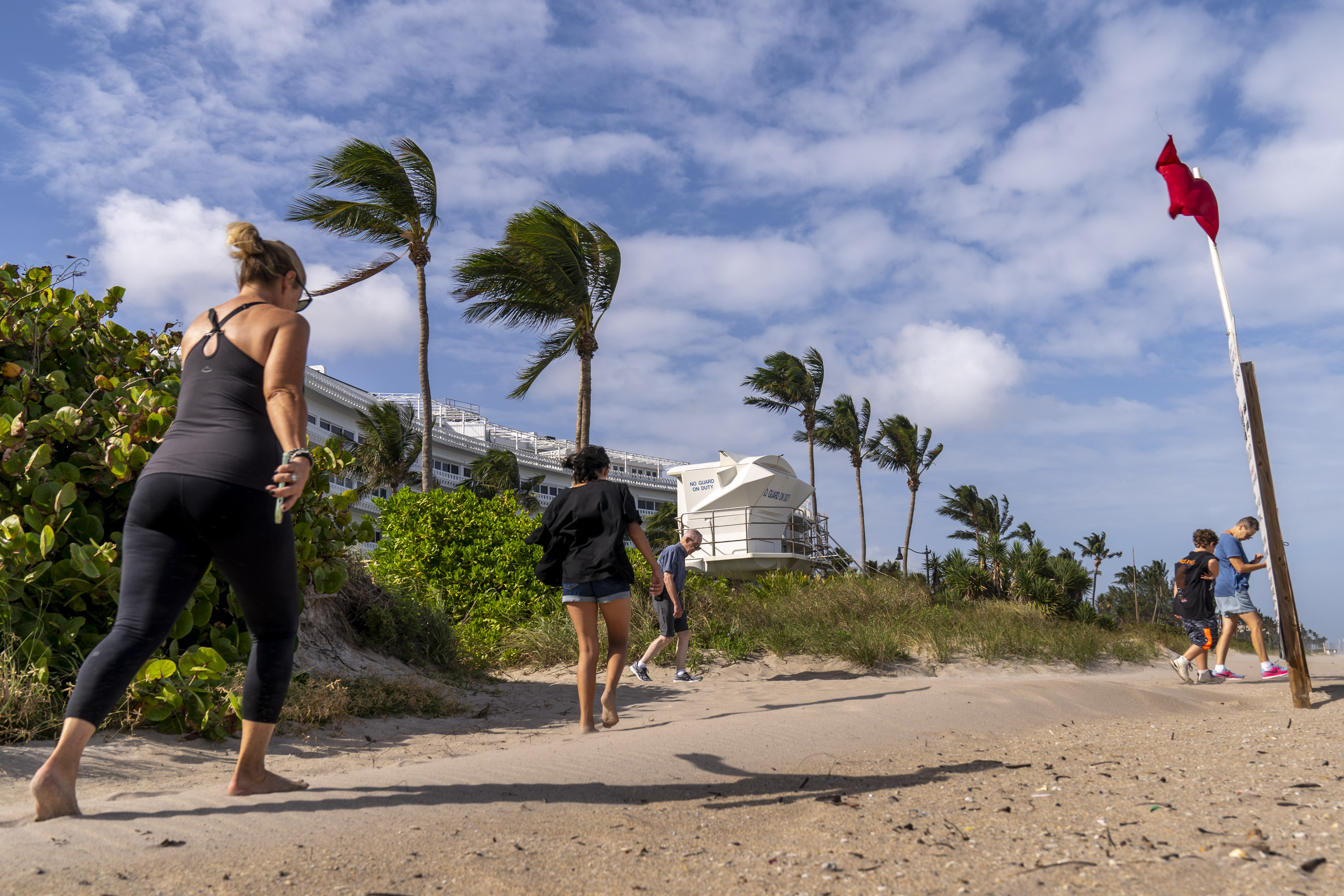 A red flag, signaling high surf and strong currents, flies in strong wind on the beach in Palm Beach, Fla., Tuesday, as Tropical Storm Nicole continues to increase in strength and is expected to make landfall along Florida's east coast early Thursday.