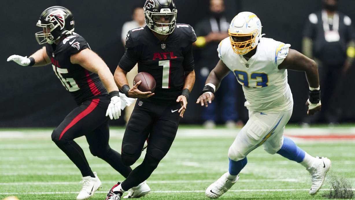 Atlanta Falcons quarterback Marcus Mariota (1) scrambles up field ahead of Los Angeles Chargers defensive tackle Otito Ogbonnia (93) during the first half of an NFL football game, Sunday, Nov. 6, 2022, in Atlanta.