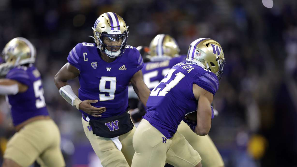 Washington quarterback Michael Penix Jr. (9) hands off to running back Wayne Taulapapa (21) against Oregon State during an NCAA collage football game, Friday, Nov. 4, 2022, in Seattle.