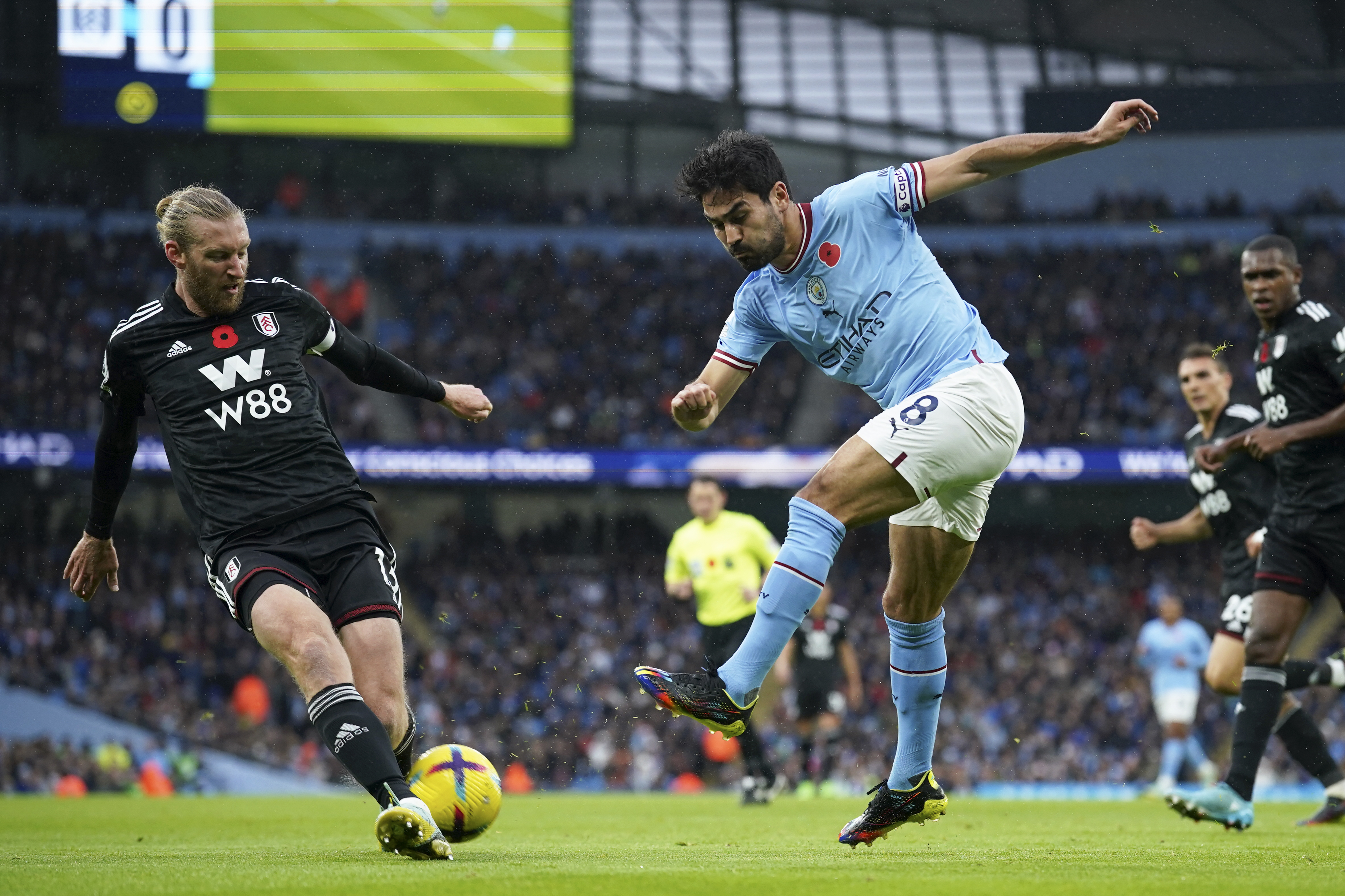 Fulham's Tim Ream, left, tries to block a shot from Manchester City's Ilkay Gundogan during the English Premier League soccer match between Manchester City and Fulham at Etihad stadium in Manchester, England, Saturday, Nov. 5, 2022. 