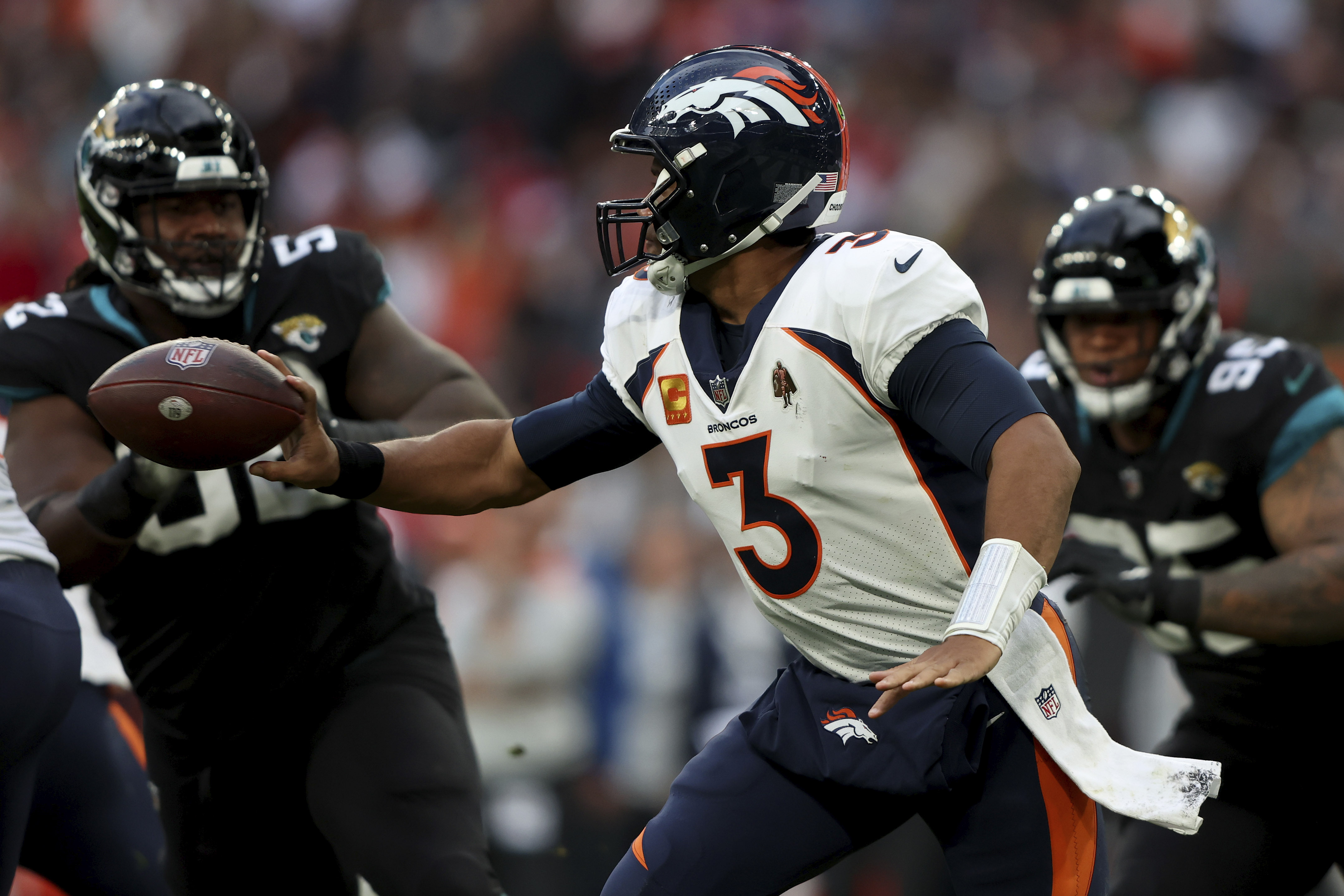 Denver Broncos quarterback Russell Wilson (3) hands off the ball during the NFL football game between Denver Broncos and Jacksonville Jaguars at Wembley Stadium in London, Sunday, Oct. 30, 2022. 