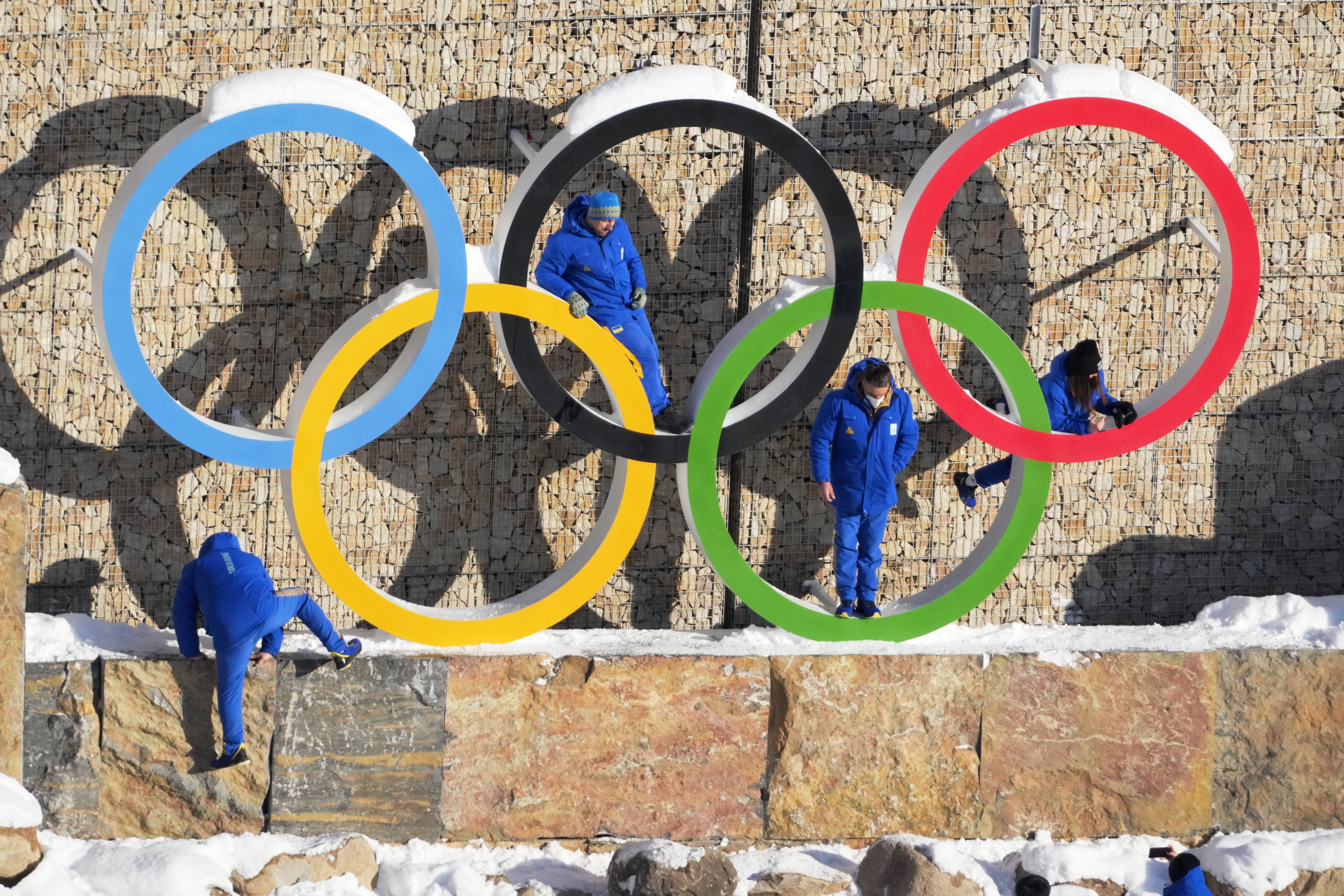 Ukraine team members climb on the Olympic Rings to pose for photo in the Olympic Village at the 2022 Winter Olympics, Feb. 14.