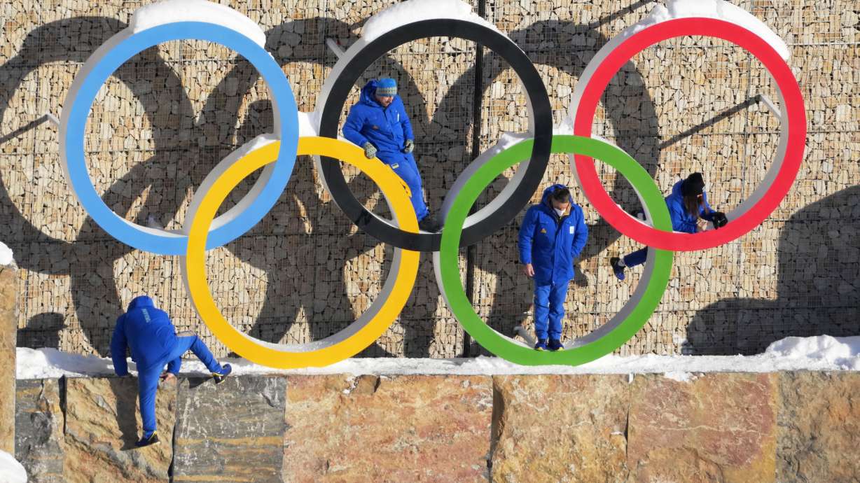 Ukraine team members climb on the Olympic Rings to pose for photo in the Olympic Village at the 2022 Winter Olympics, Feb. 14.