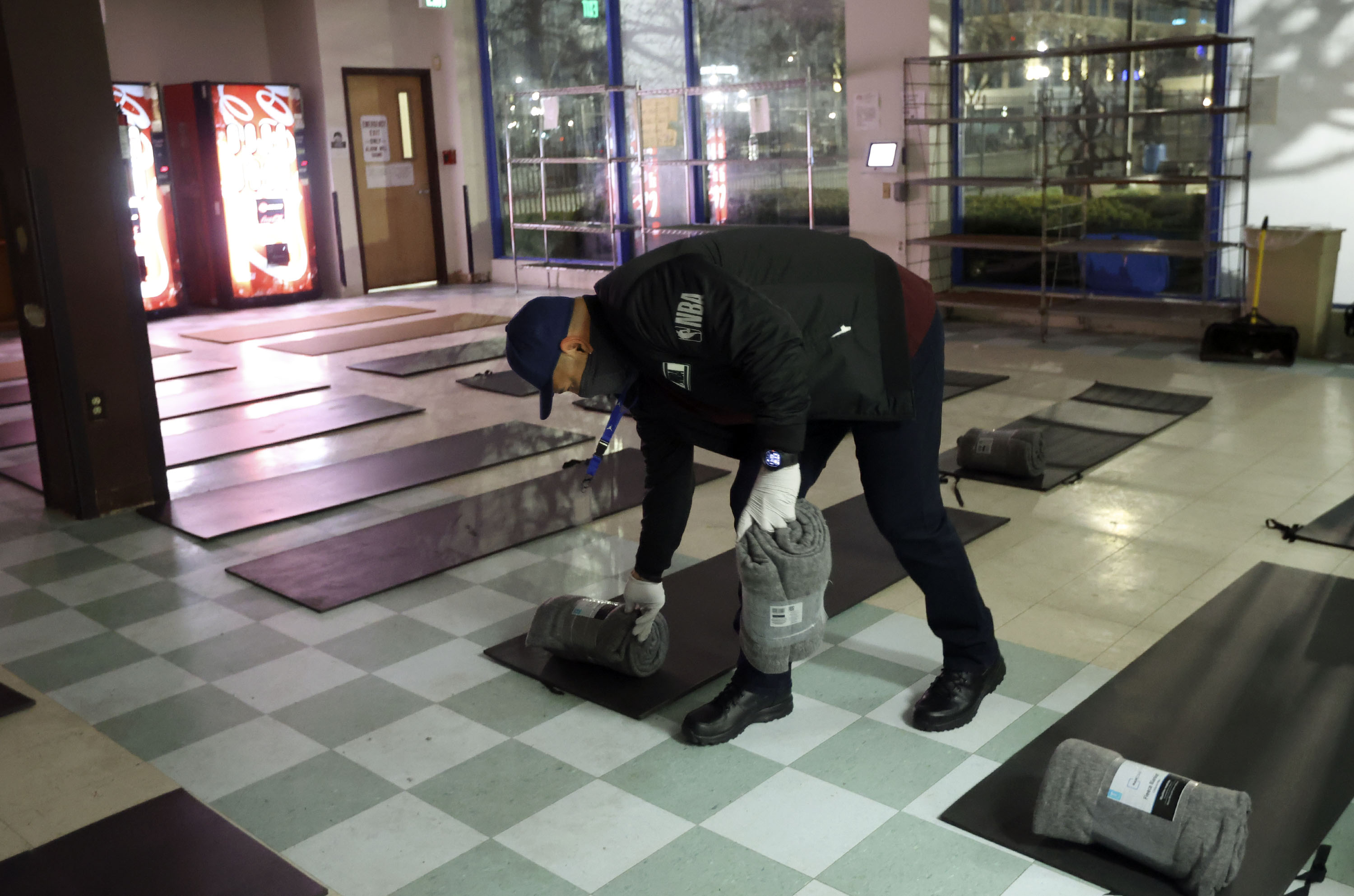 Luis Perez, Volunteers of America shift lead, sets up overflow beds for the homeless in the Weigand Center for the Weigand Winter Overflow in Salt Lake City on Jan. 10. This week's winter storm brought with it the first real test of a new state law requiring cities to come together and submit a plan for summer and winter overflow to the Utah Office of Homeless Services.