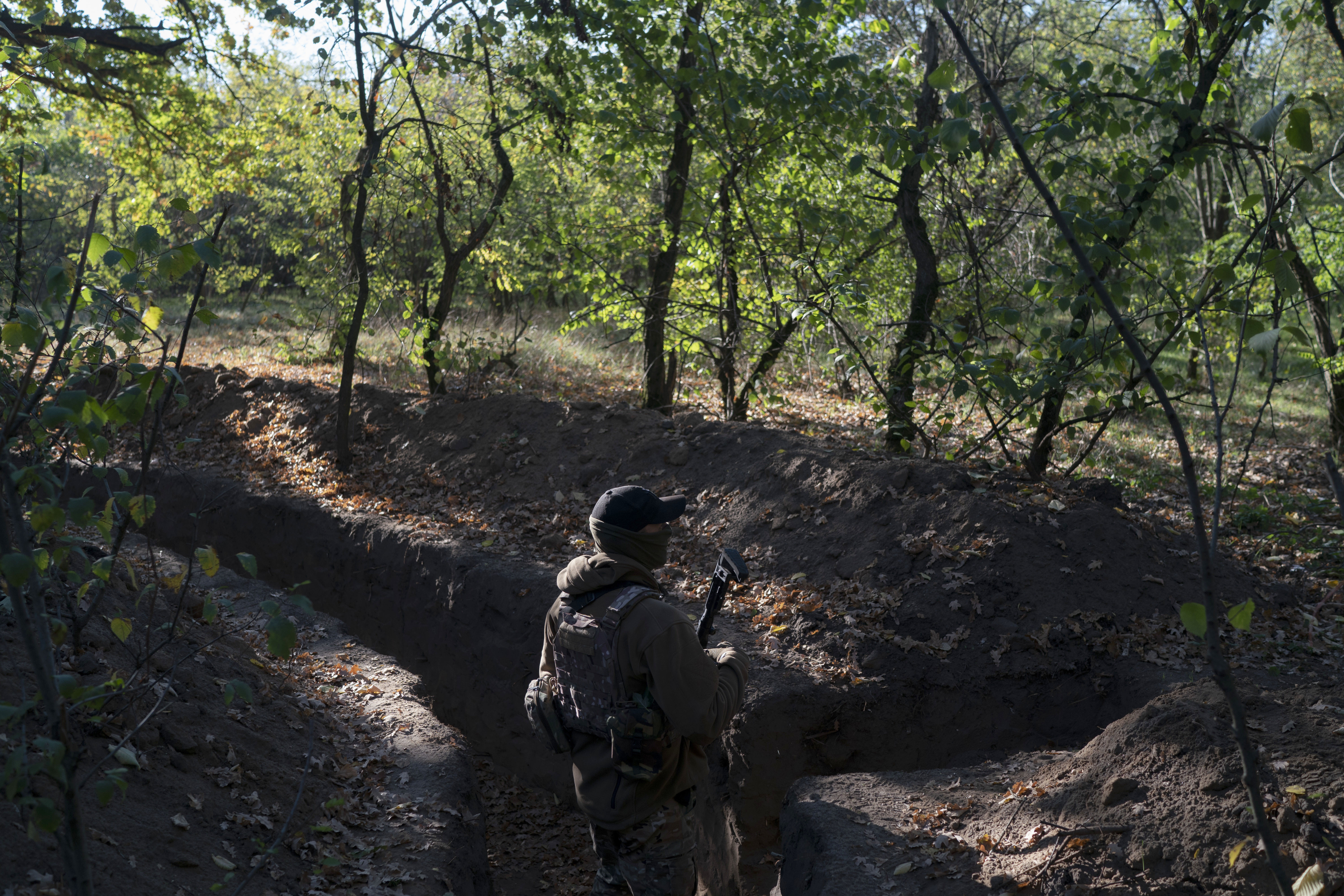 A Ukrainian serviceman checks the trenches dug by Russian soldiers in a retaken area in Kherson region, Ukraine, Oct. 12. Ukrainian officials have acknowledged that Russian troops had no choice but to flee a key southern city, but stopped short of declaring victory in Kherson.