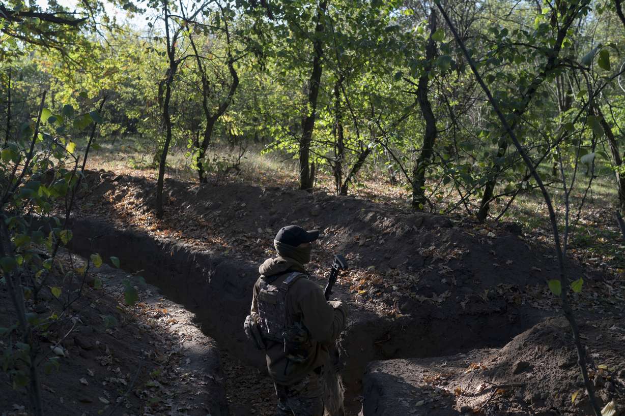 A Ukrainian serviceman checks the trenches dug by Russian soldiers in a retaken area in Kherson region, Ukraine, Oct. 12. Ukrainian officials have acknowledged that Russian troops had no choice but to flee a key southern city, but stopped short of declaring victory in Kherson.