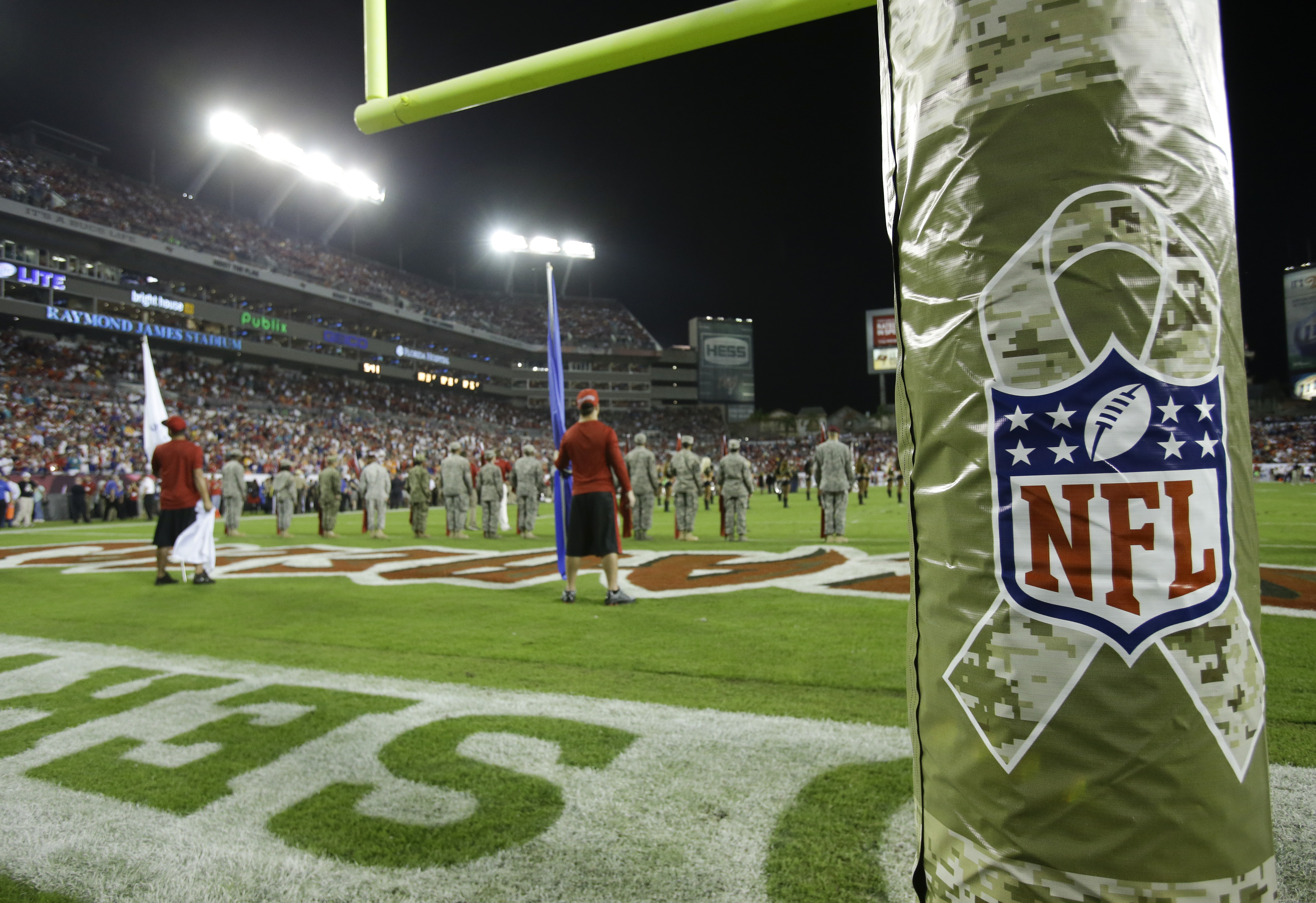 FILE - A goal posts is wrapped with the NFL logo in honor of Veterans Day during an NFL football game between the Tampa Bay Buccaneers and the Miami Dolphins in Tampa, Fla., on Nov. 11, 2013. Fox’s NFL pregame show is going international for the first time in 13 years for their annual Veterans Day show. This week’s “Fox NFL Sunday” will originate from Al Udeid Air Base in Qatar.  