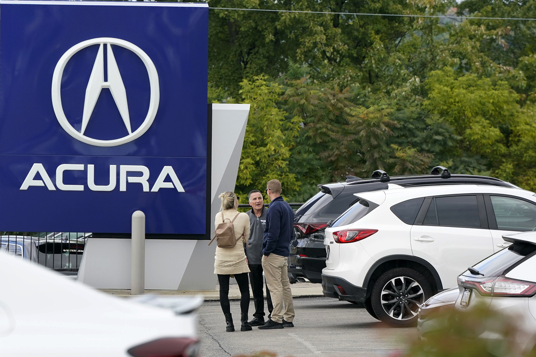 A salesman talks with customers at an Acura dealer in Wexford, Pa., on Sept. 29. The Labor Department is expected to report consumer prices on Thursday.