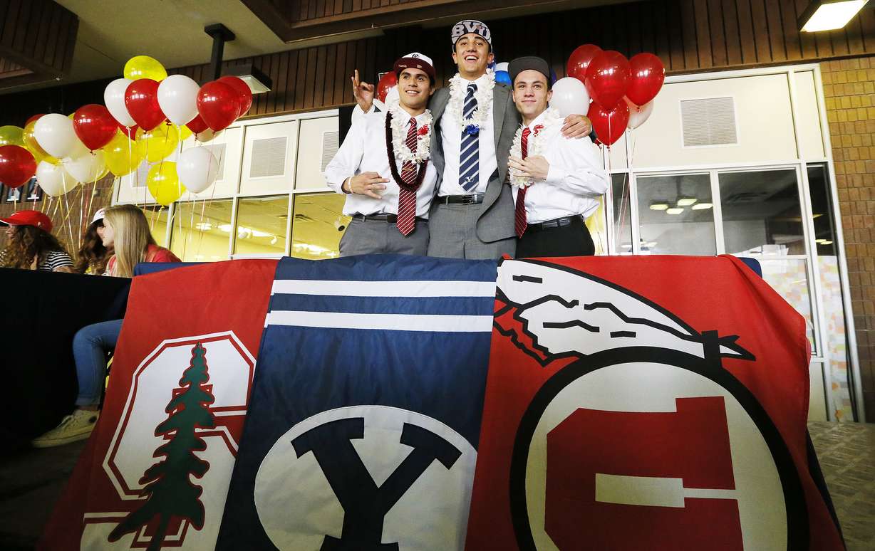 Timpview football players Gabe Reid, Devin Kaufusi and Britain Covey hug as they sign their Letters of Intent in Provo Wednesday, Feb. 4, 2015.