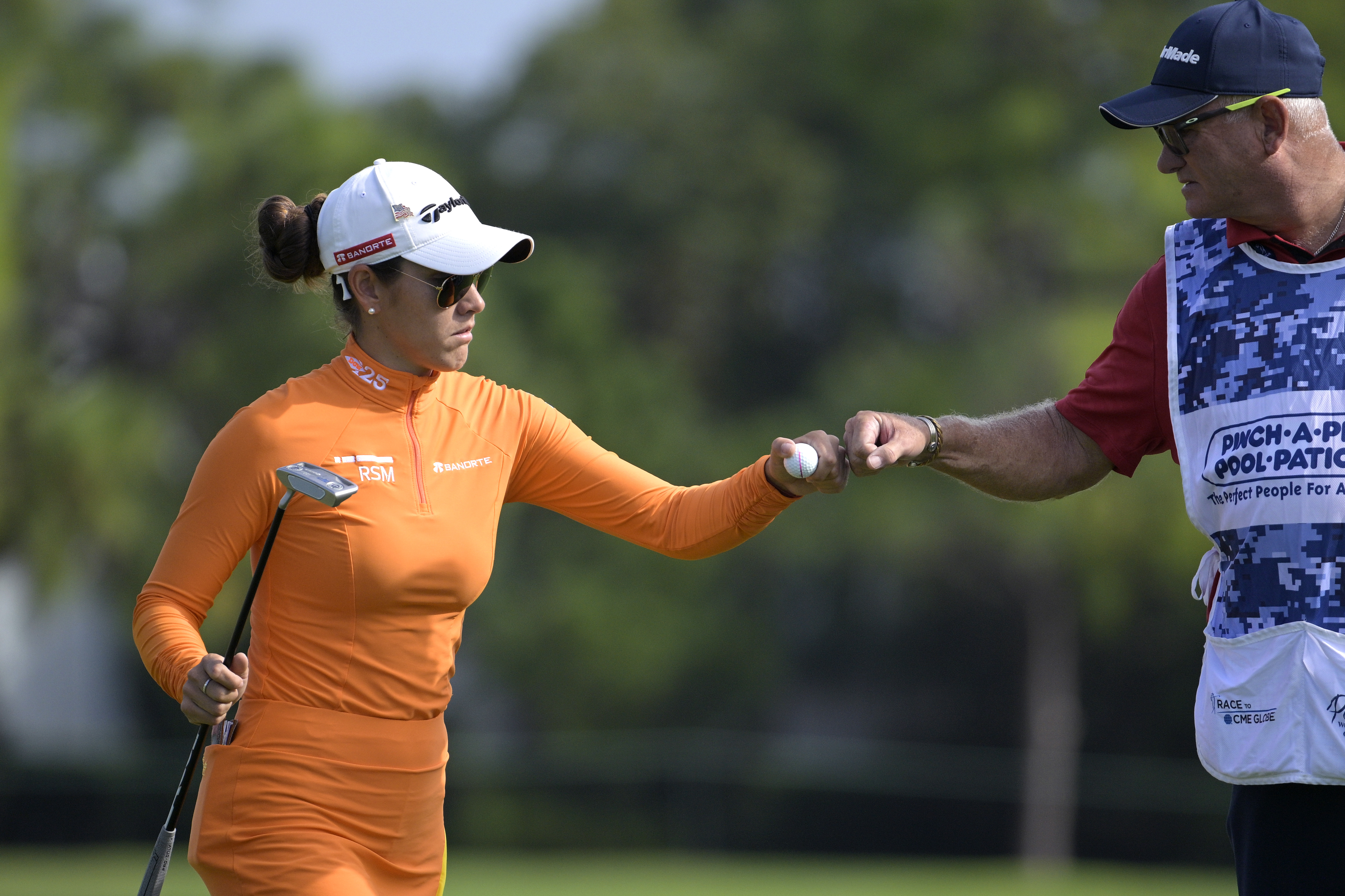 Maria Fassi, left, of Mexico, gets a fist bump from her caddie after making a putt on the eighth green during the first round of the LPGA Pelican Women's Championship golf tournament at Pelican Golf Club, Friday, Nov. 11, 2022, in Belleair, Fla. 