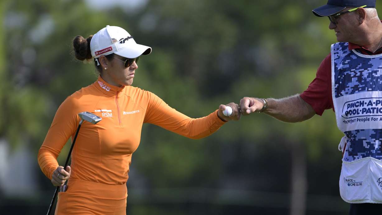 Maria Fassi, left, of Mexico, gets a fist bump from her caddie after making a putt on the eighth green during the first round of the LPGA Pelican Women's Championship golf tournament at Pelican Golf Club, Friday, Nov. 11, 2022, in Belleair, Fla.