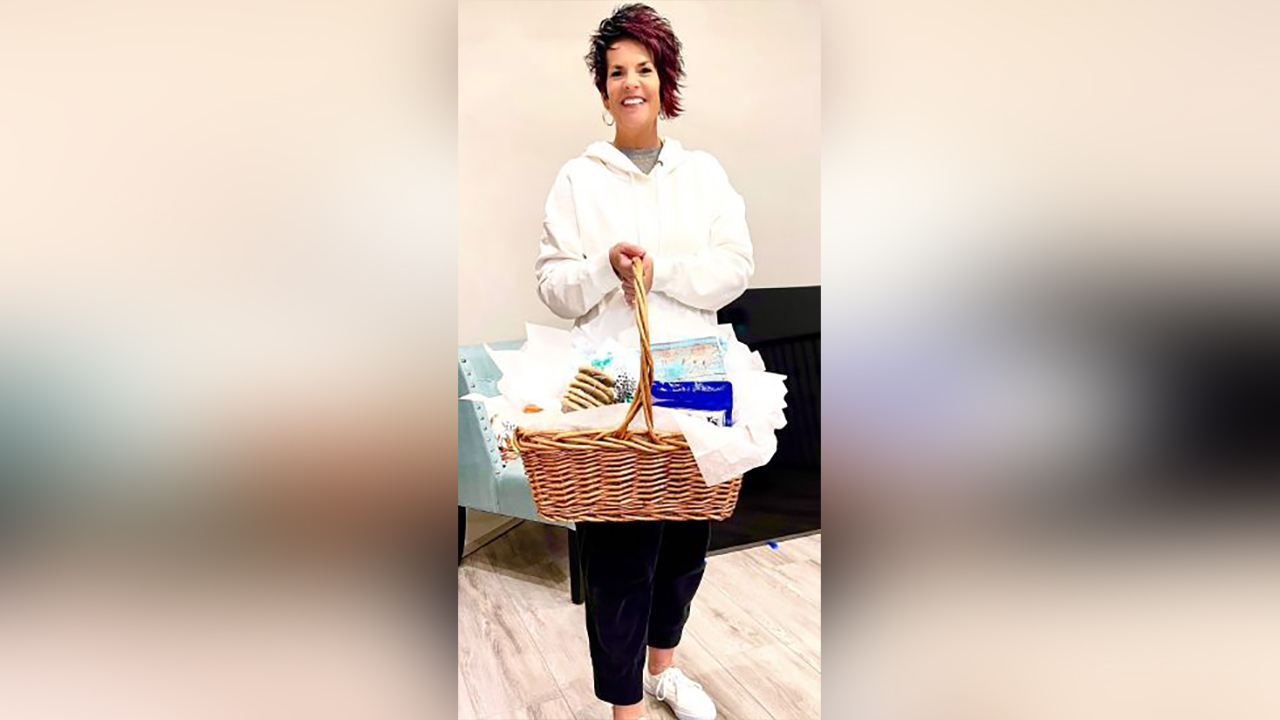 RaQuett Stroud, who founded the Juniper Tree to provide gift baskets like the one she's holding here, to others fighting their own trials in life.