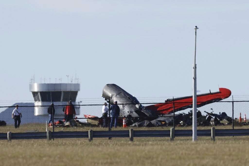 A damaged plane sits at the Dallas Executive Airport in Dallas after two historic military planes collided and crashed on Saturday.