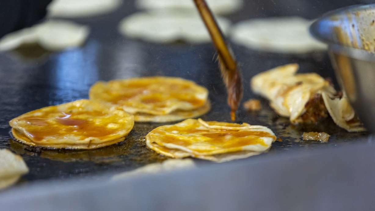 Claudia Martinez brushes tortillas at TacoMania in Riverton on Saturday.
