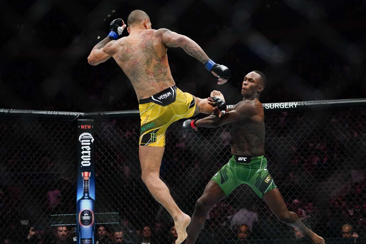 Brazil's Alex Pereira, left, kicks Nigeria's Israel Adesanya during the first round of a middleweight bout at the UFC 281 mixed martial arts event early Sunday, Nov. 13, 2022, in New York. Pereira stopped Adesanya in the fifth round.