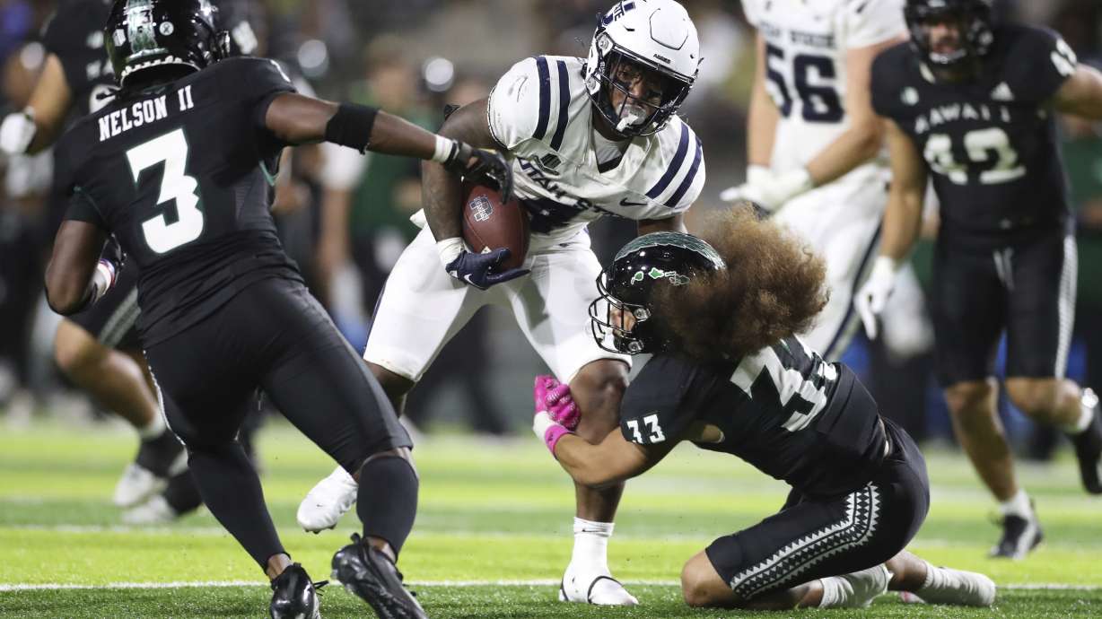 Utah State running back Calvin Tyler Jr. (4) gets past Hawaii defensive back Peter Manuma (33) during the second quarter of an NCAA college football game Saturday, Nov. 12, 2022, in Honolulu.
