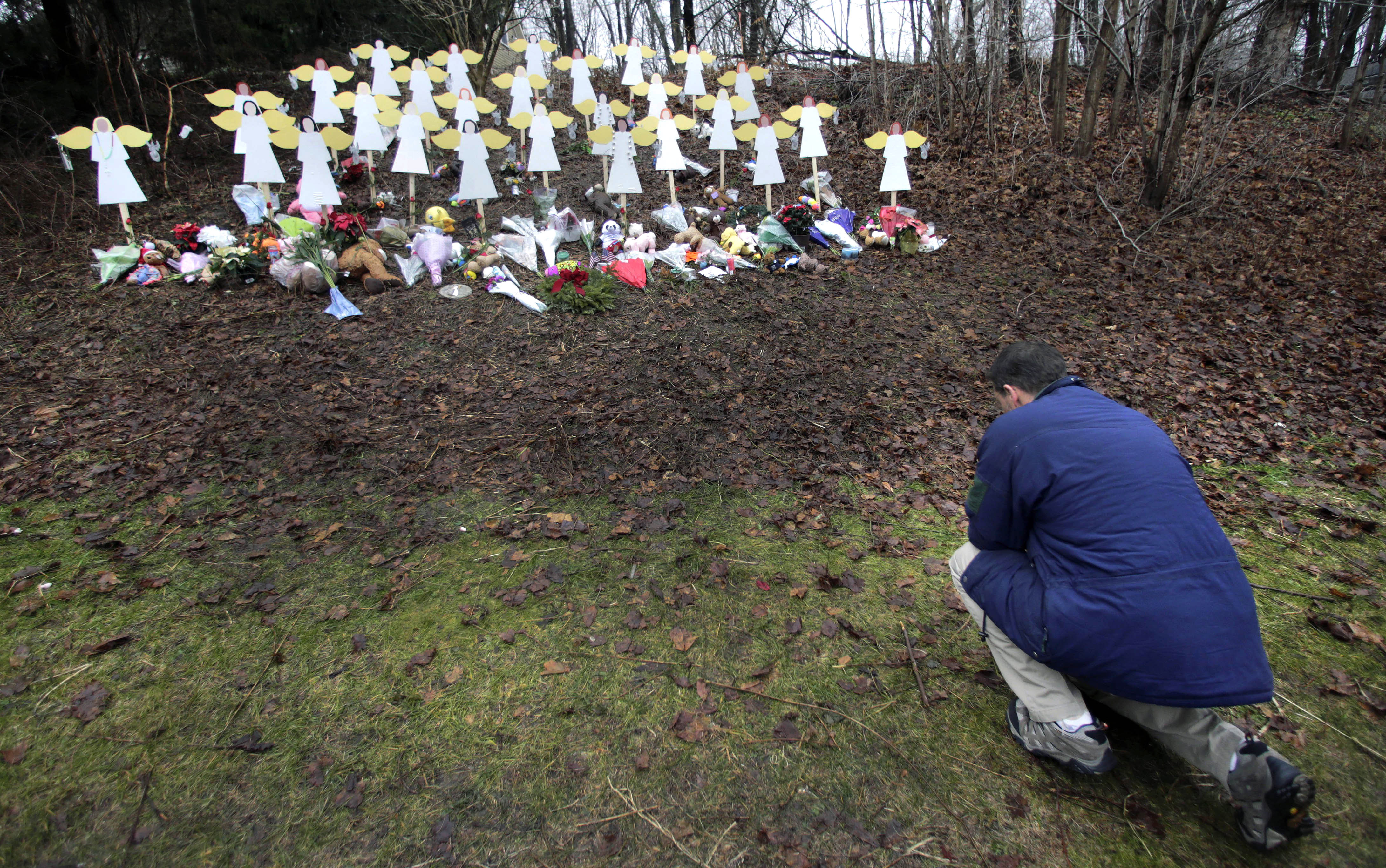 Robert Soltis, of Newtown, Conn., pauses after making the sign of the cross at a memorial to Sandy Hook Elementary School shooting victims in Newtown. A memorial to the 20 first graders and six educators killed in the Sandy Hook Elementary School shooting opened to the public Sunday a month before the 10th anniversary of the massacre. 