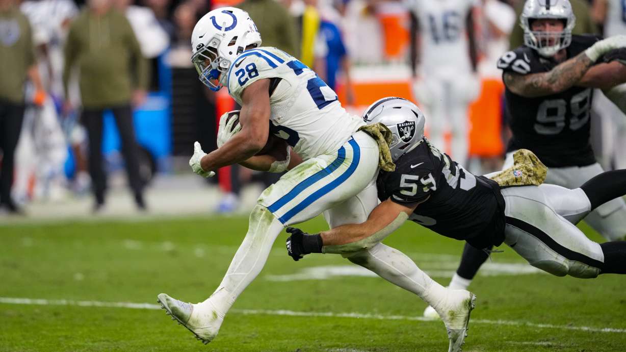 Indianapolis Colts running back Jonathan Taylor (28) is tackled by Las Vegas Raiders linebacker Luke Masterson (59) in the first half of an NFL football game in Las Vegas, Sunday, Nov. 13, 2022.