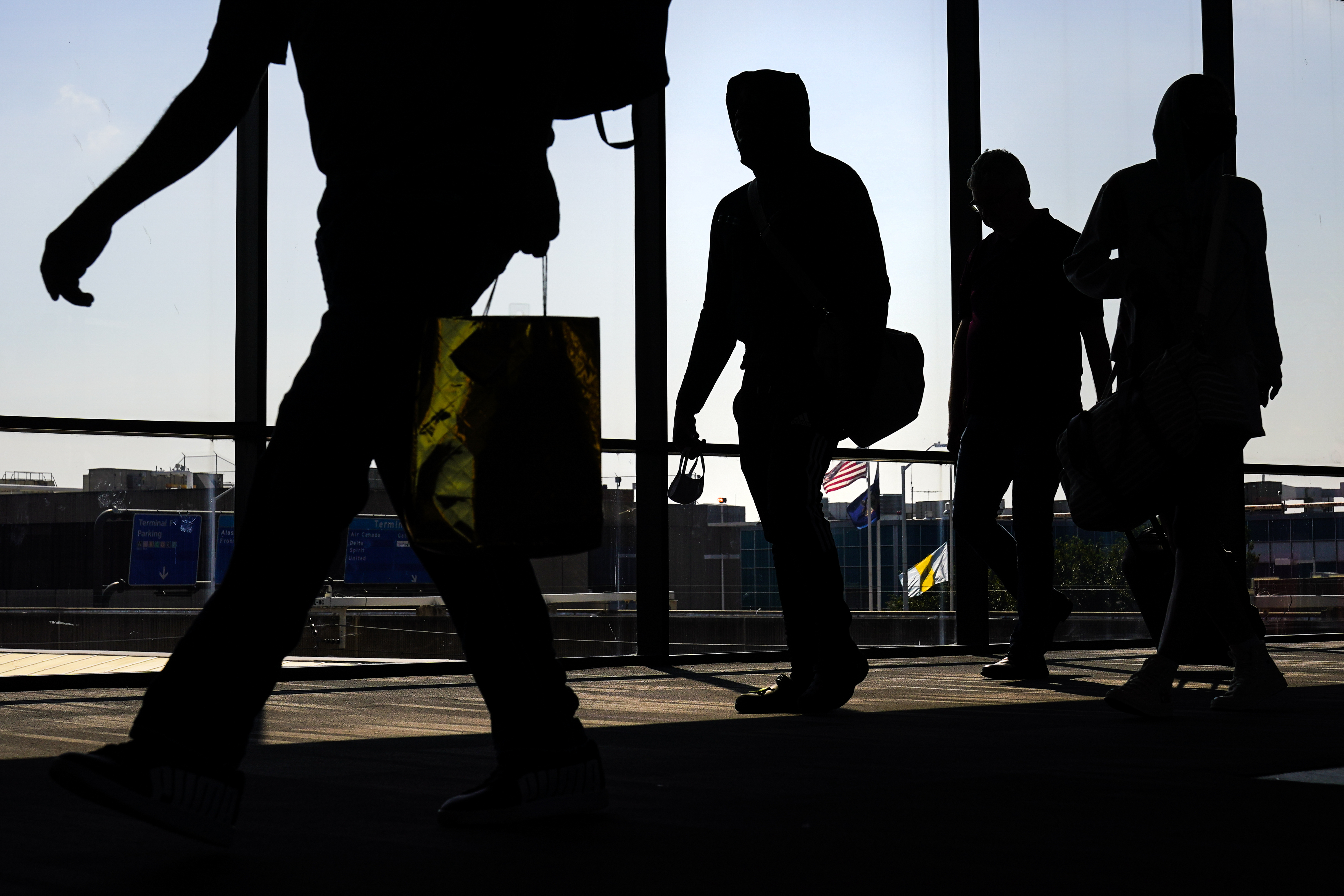 Arriving passengers move toward the baggage claim area at Philadelphia International Airport in Philadelphia on July 1. Travelers will probably pay more for airline tickets or a hotel room around the holidays than they did over last Thanksgiving or Christmas. 