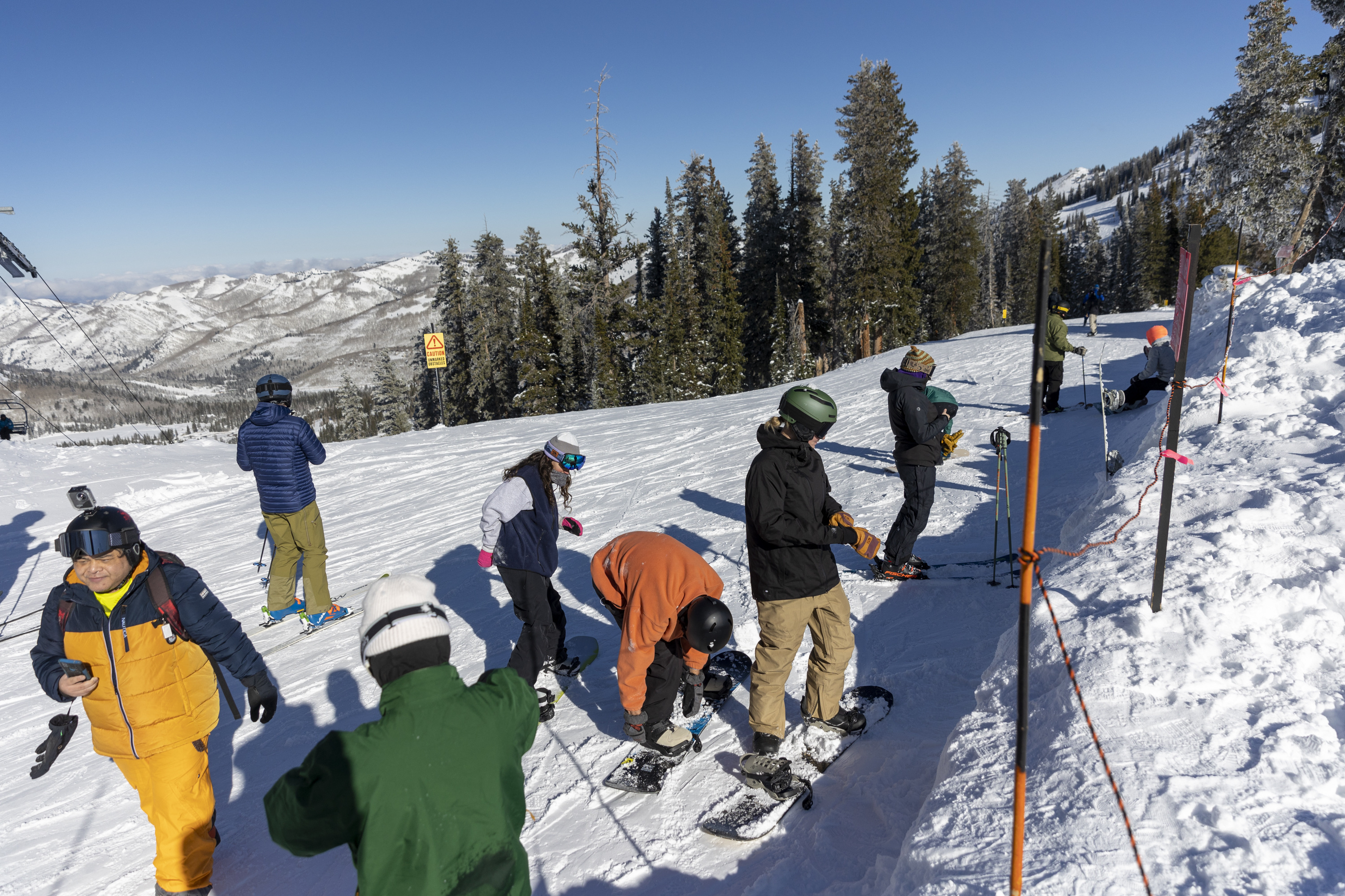 Skiers and snowboarders strap in and take photos before taking a run at Brighton Resort in Big Cottonwood Canyon on Monday.