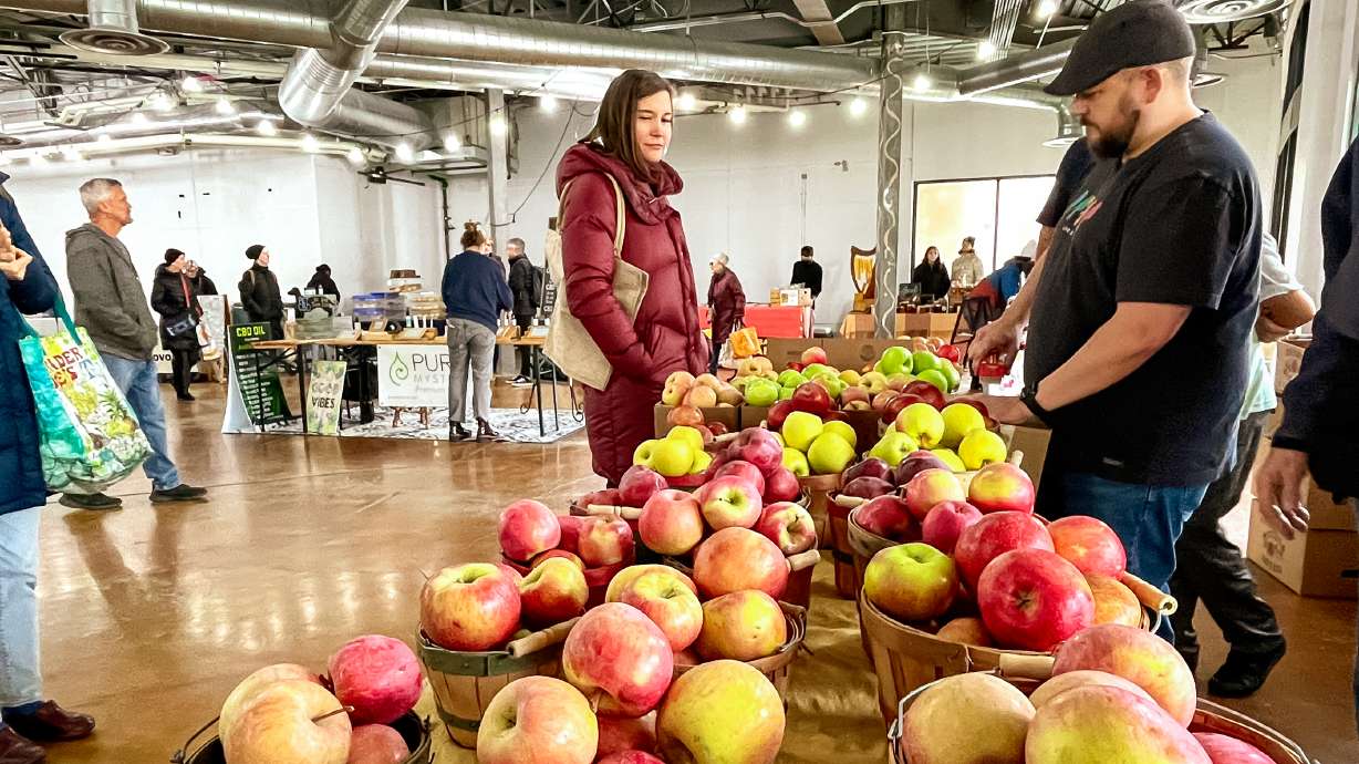 Salt Lake City Mayor Erin Mendenhall checks out a Pyne Farms apple stand at the Salt Lake City Downtown Farmers Market in Salt Lake City on Nov. 12, 2022. The winter market has a new home at The Leonardo, beginning Nov. 15.