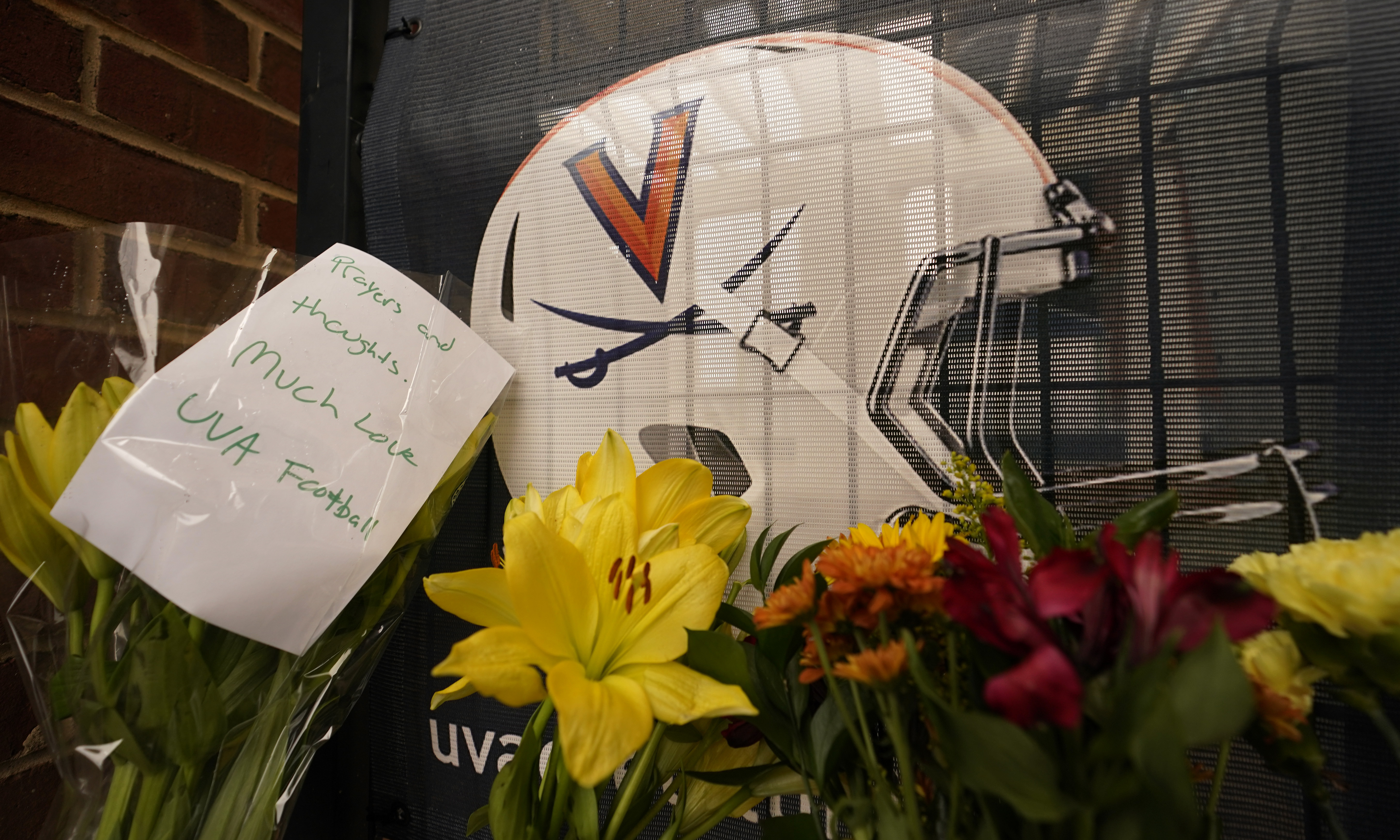 Memorial flowers and notes line walkway at Scott Stadium after three football players were killed in a shooting on the grounds of the University of Virginia Tuesday Nov. 15, 2022, in Charlottesville. Va.