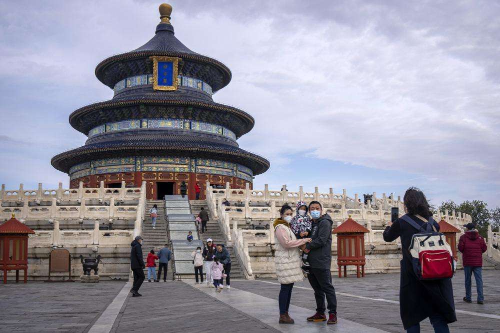 A family poses for photos at the Temple of Heaven in Beijing, Saturday. The world's population is projected to hit an estimated 8 billion people on Tuesday, according to a United Nations projection.
