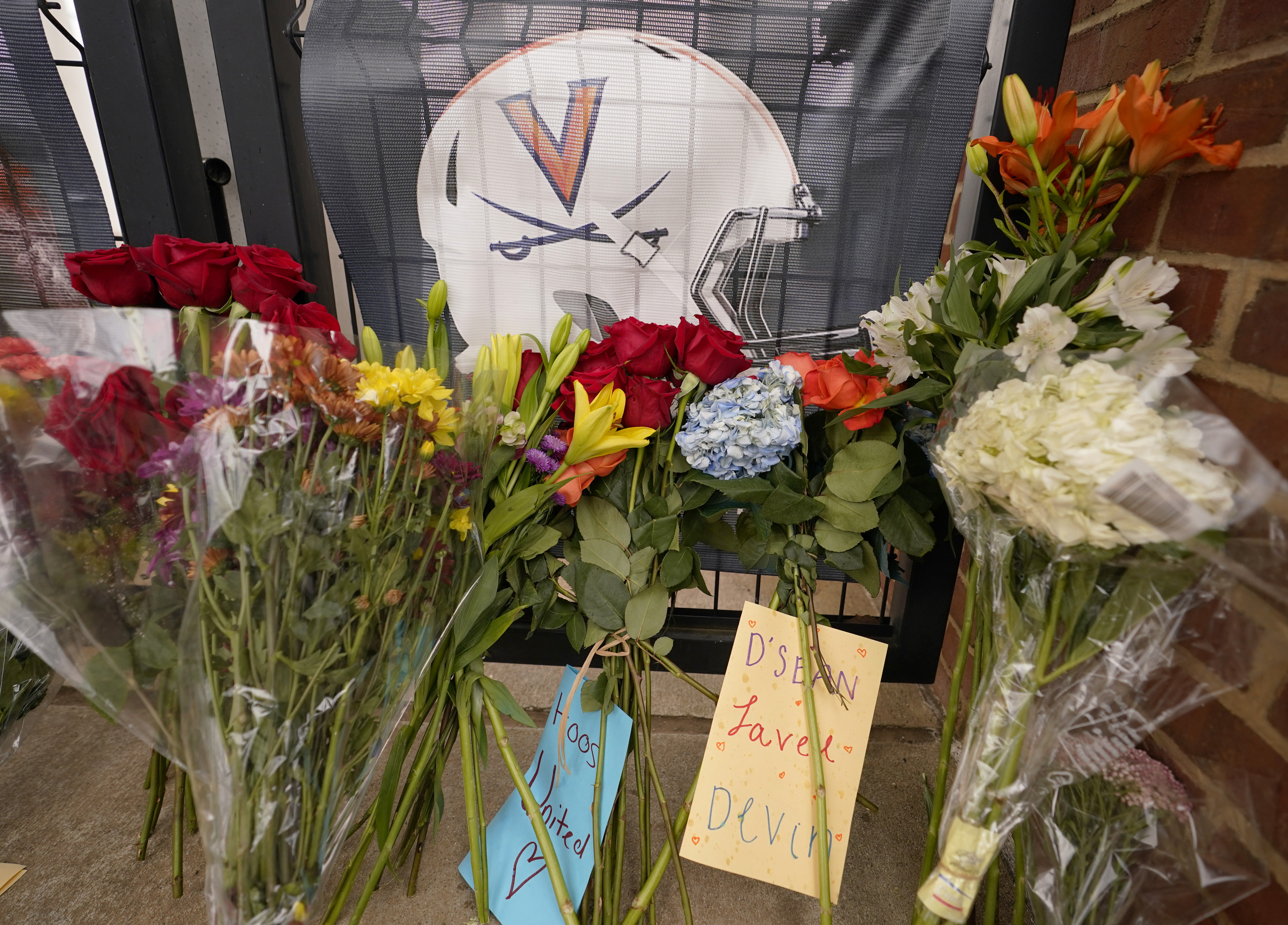 Memorial flowers and notes line walkway at Scott Stadium after three football players were killed in a shooting on the grounds of the University of Virginia Tuesday Nov. 15, 2022, in Charlottesville. Va. Authorities say three people have been killed and two others were wounded in a shooting at the University of Virginia and a student suspect is in custody.
