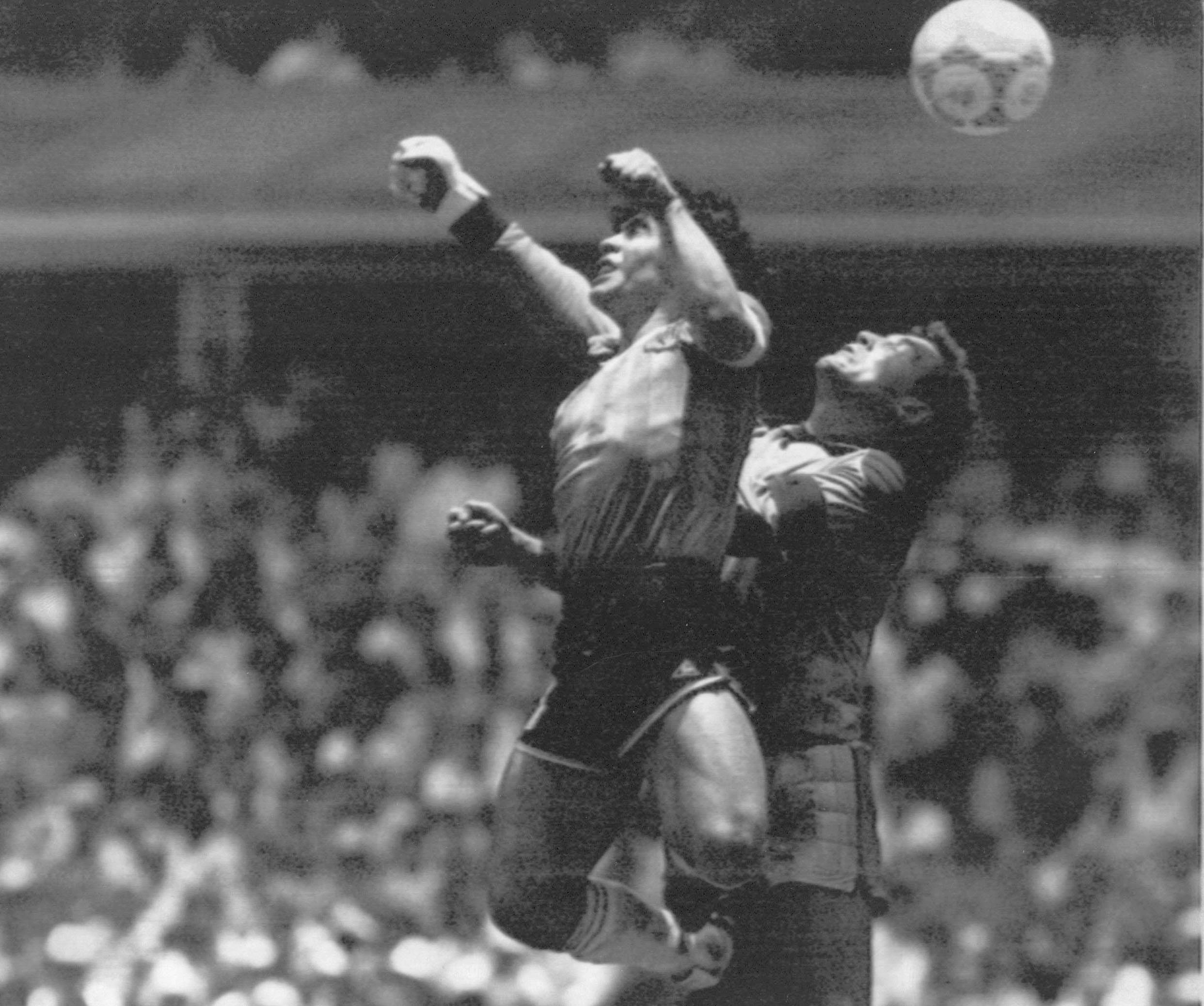 FILE - Argentina's Diego Maradona, left, beats England goalkeeper Peter Shilton to a high ball and scores his first of two goals in a World Cup quarterfinal soccer match, in Mexico City on June 22, 1986. This goal has gone down as the "Hand of God" as Maradona used his left fist to knock a ball past England's Shilton. 