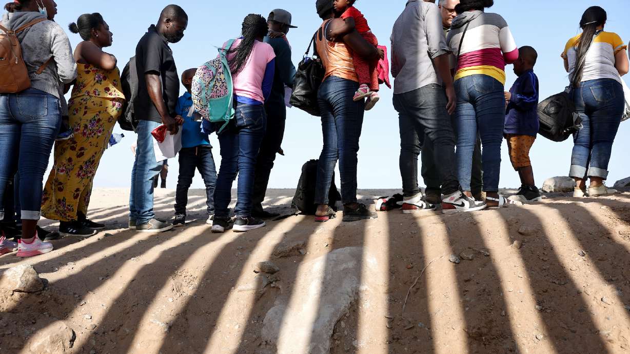 Immigrants from Haiti, who crossed through a gap in the U.S.-Mexico border barrier, wait in line to be processed by the U.S. Border Patrol on May 20 in Yuma, Arizona. A federal judge on Wednesday put on hold for five weeks his ruling striking down the controversial Title 42 immigration policy