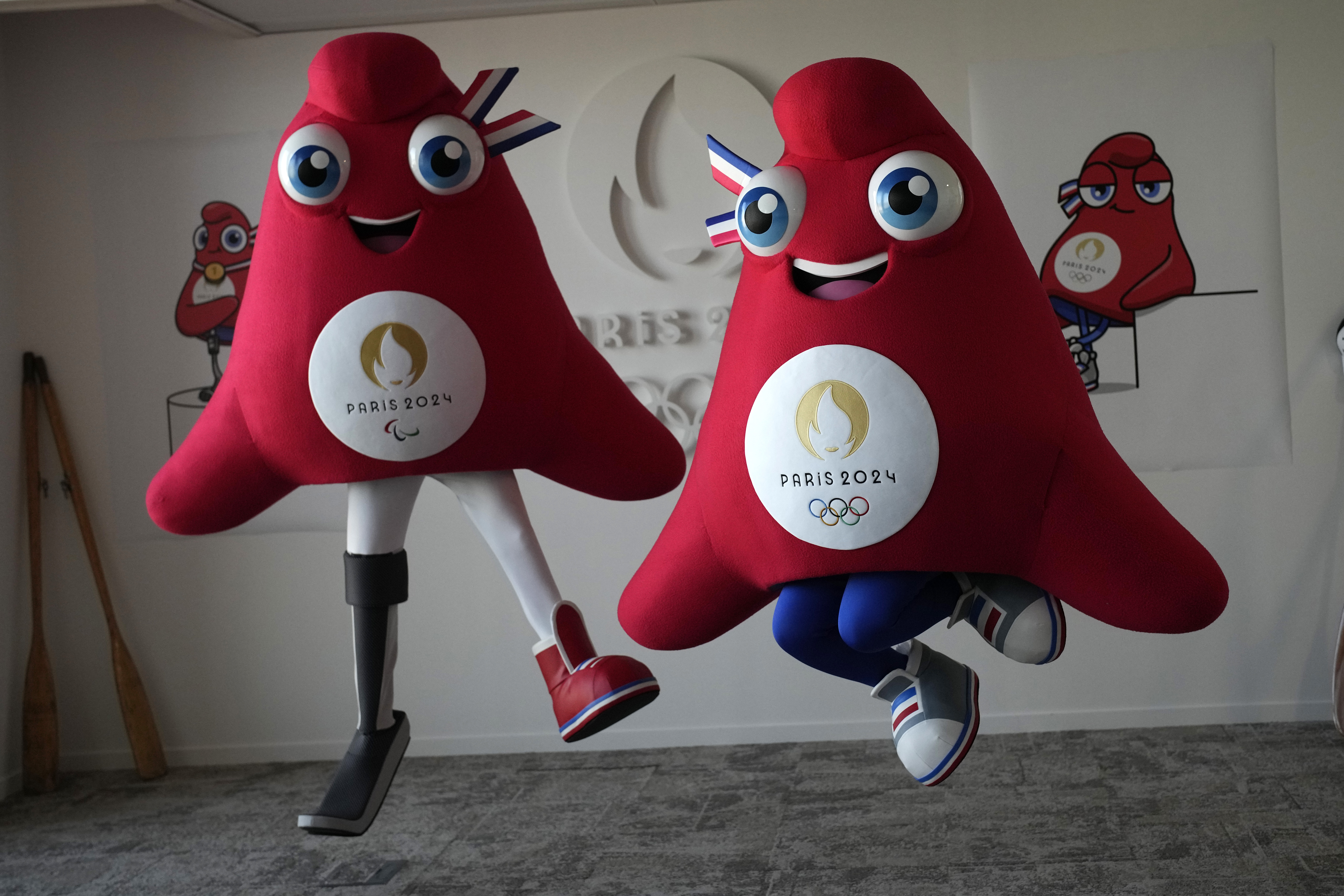 FILE - Mascots of the 2024 Paris Olympic Games, right, and Paralympics Games, a Phrygian cap, jump during a preview in Saint Denis, outside Paris, on Thursday, Nov. 10, 2022.  Izzy, the much-hated blob that represented the 1996 Atlanta Games has been supplanted by the mascot for the Paris Olympics — a Phrygian cap. 