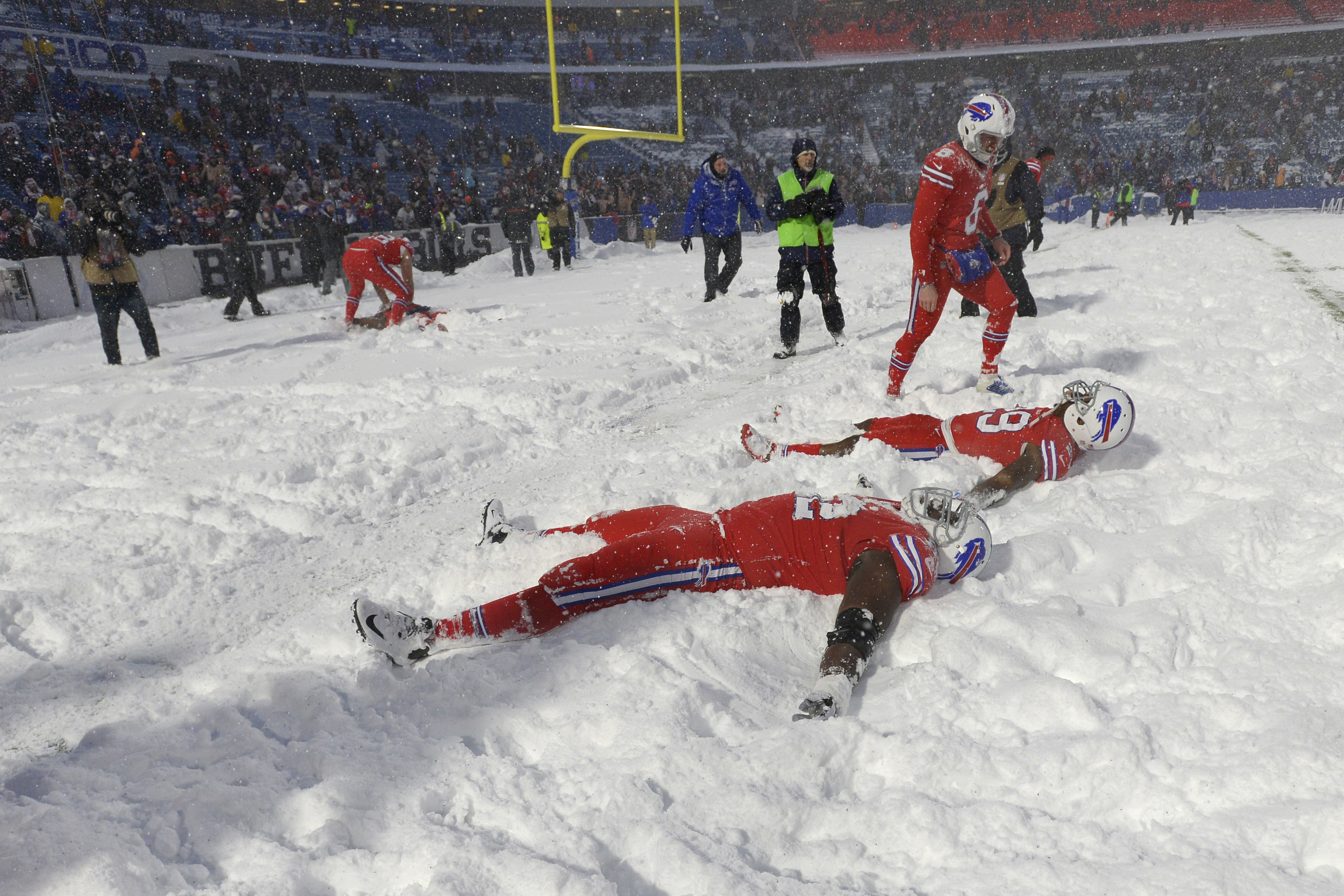 FILE - Buffalo Bills players make snow angels in the snow after defeating the Indianapolis Colts after an NFL football game, on Sunday, Dec. 10, 2017, in Orchard Park, N.Y. The NFL is monitoring the weather and has contingency plans in place in the event a lake-effect snowstorm hitting the Buffalo disrupts the Bills ability to host the Cleveland Browns on Sunday, Nov. 20, 2022. 