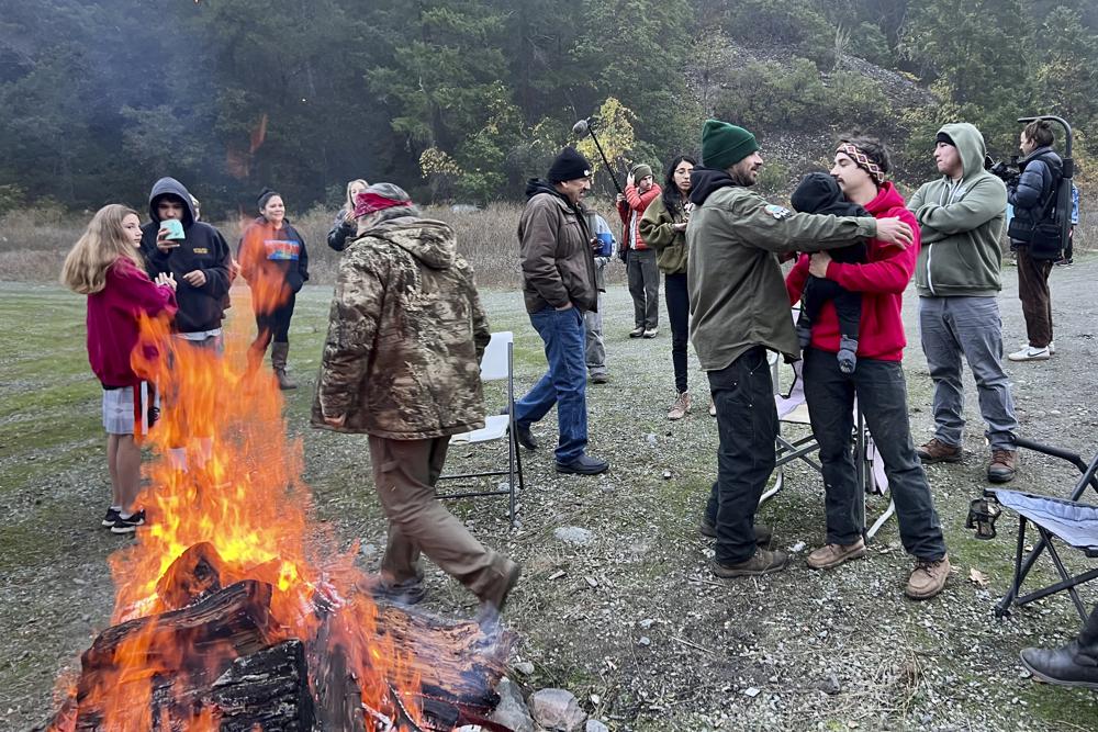 Members of the Yurok, Karuk and Hoopa Valley tribes and their supporters gather on a sand bar in the Klamath River near Orleans, Calif., to watch the Federal Energy Regulatory Commission meeting by satellite uplink on the fate of four dams on the lower Klamath River, Thursday.