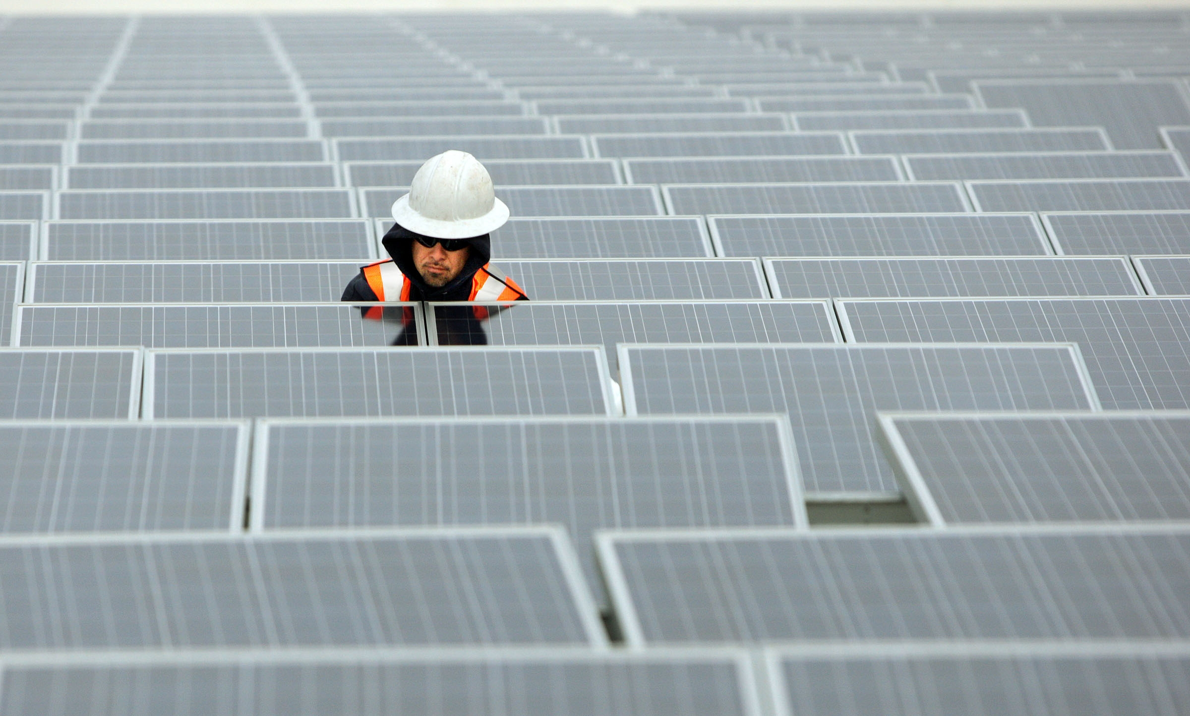 Jose Perez installs solar panels on the roof of the Salt Palace Convention Center in Salt Lake City on Feb. 1, 2012. Funding is coming to the city's west side to increase solar energy there. 