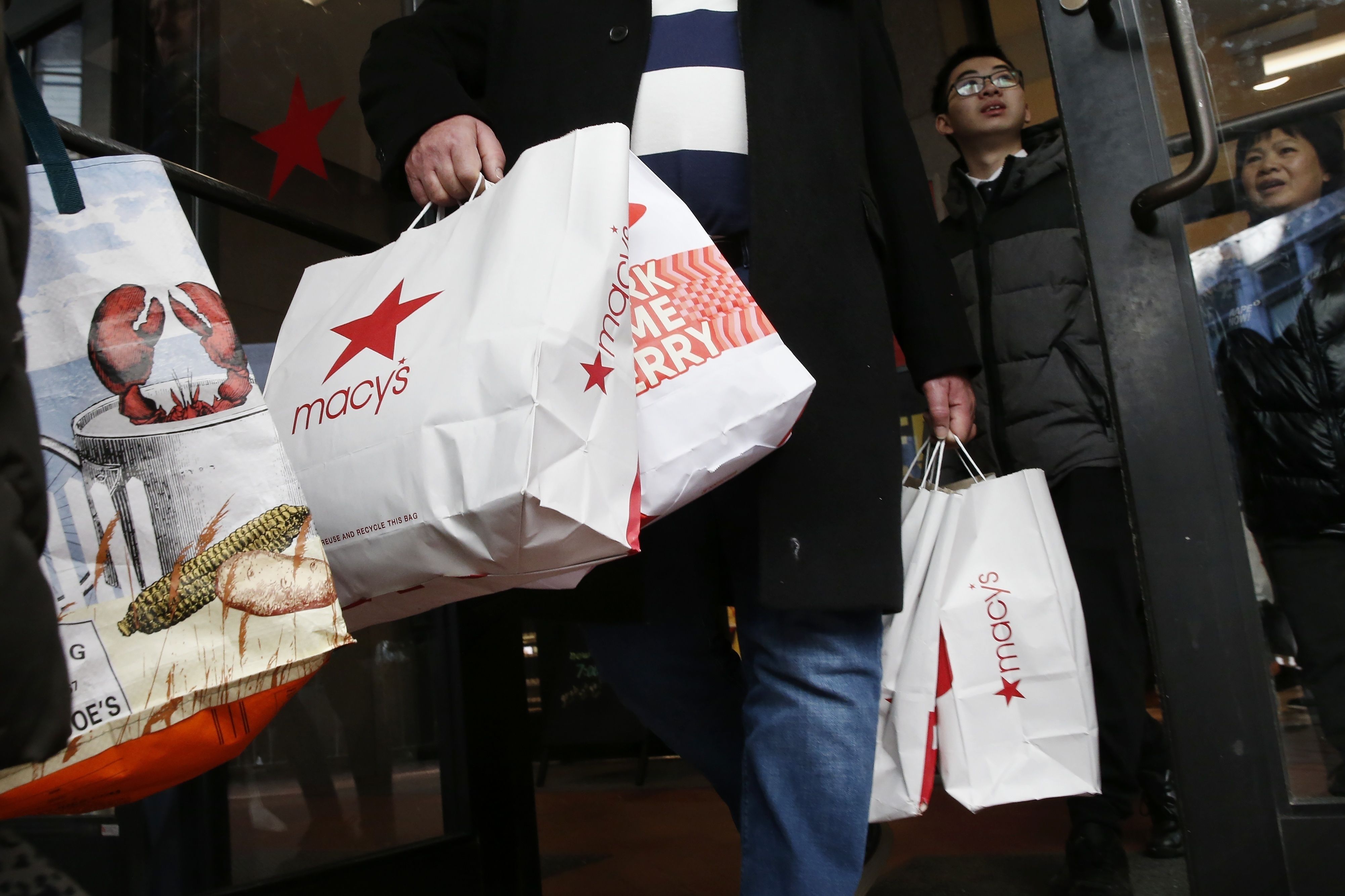 Black Friday shoppers leave Macy’s in Boston on Nov. 29, 2019. Some store-branded retail credit cards have increased their interest rates significantly.