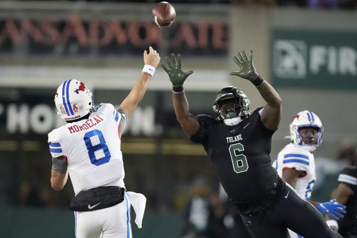 Southern Methodist quarterback Tanner Mordecai (8) passes under pressure from Tulane linebacker Darius Hodges (6) during the first half of an NCAA college football game in New Orleans, Thursday, Nov. 17, 2022.