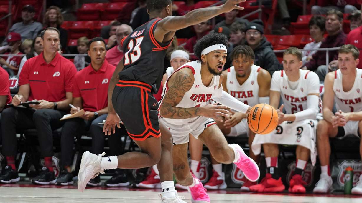 Utah guard Mike Saunders Jr. drives as Sam Houston State guard Jaden Ray (13) defends during the second half of an NCAA college basketball game Thursday, Nov. 17, 2022, in Salt Lake City.