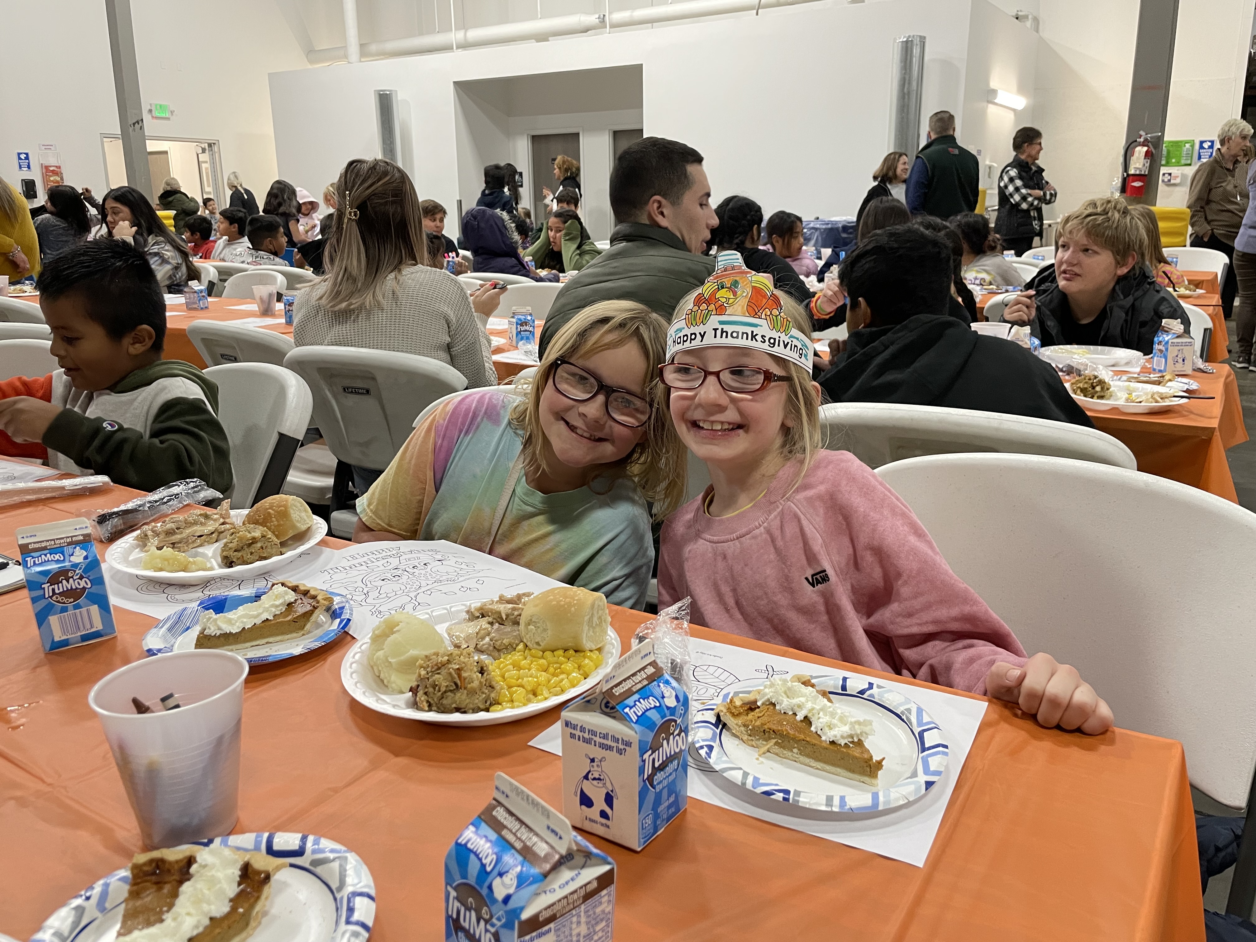 Two young girls enjoy a meal from the Utah Food Bank Kids Cafe Thanksgiving Dinner. The food bank is asking Utahns to donate whatever they can to help fight hunger statewide this holiday season.