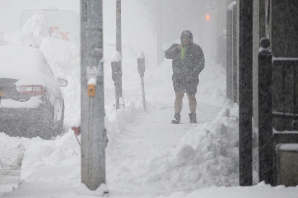 A person walks through downtown in the snow Friday in Buffalo, N.Y. A dangerous lake-effect snowstorm paralyzed parts of western and northern New York, with nearly two feet of snow already on the ground in some places and possibly much more on the way.