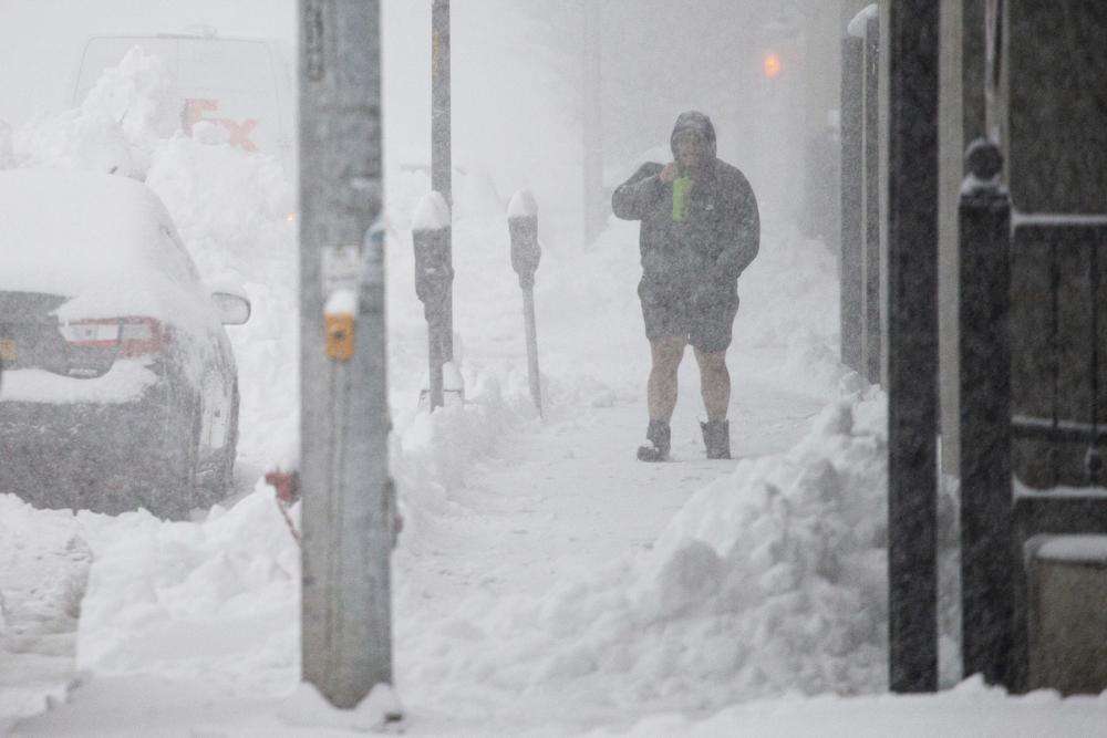 A person walks through downtown in the snow Friday in Buffalo, N.Y. A dangerous lake-effect snowstorm paralyzed parts of western and northern New York, with nearly two feet of snow already on the ground in some places and possibly much more on the way.