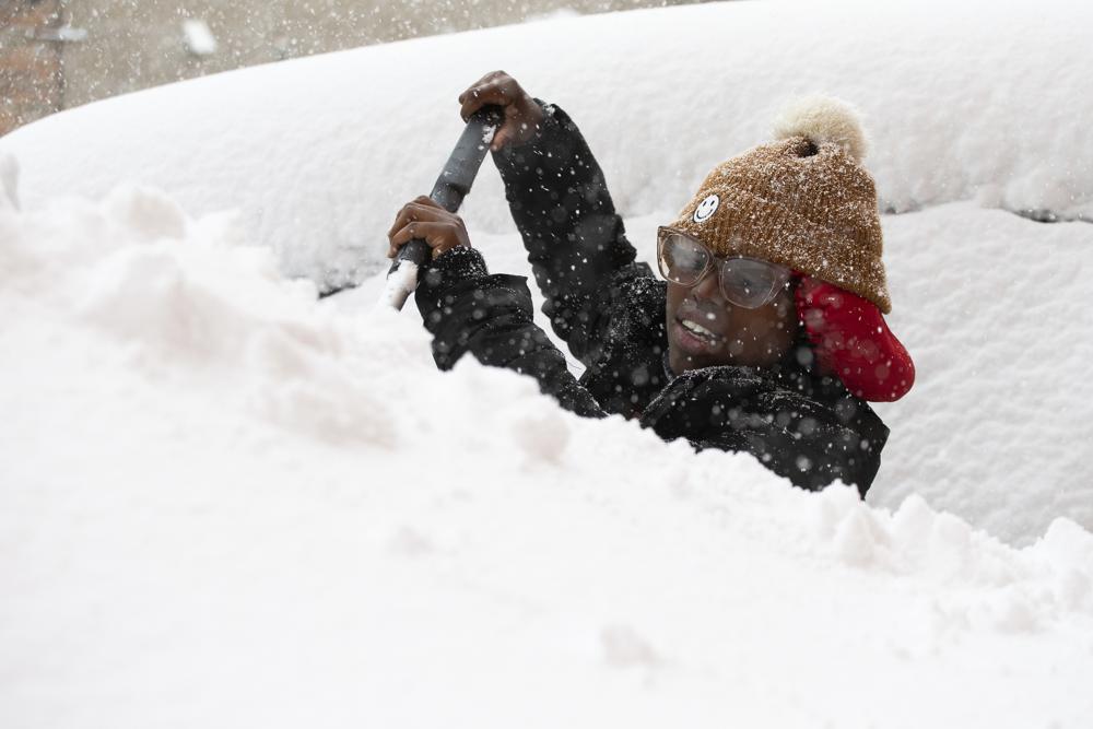 Zaria Black, 24, from Buffalo, clears off her car as snow falls Friday in Buffalo, N.Y. A dangerous lake-effect snowstorm paralyzed parts of western and northern New York, with nearly two feet of snow already on the ground in some places and possibly much more on the way. 