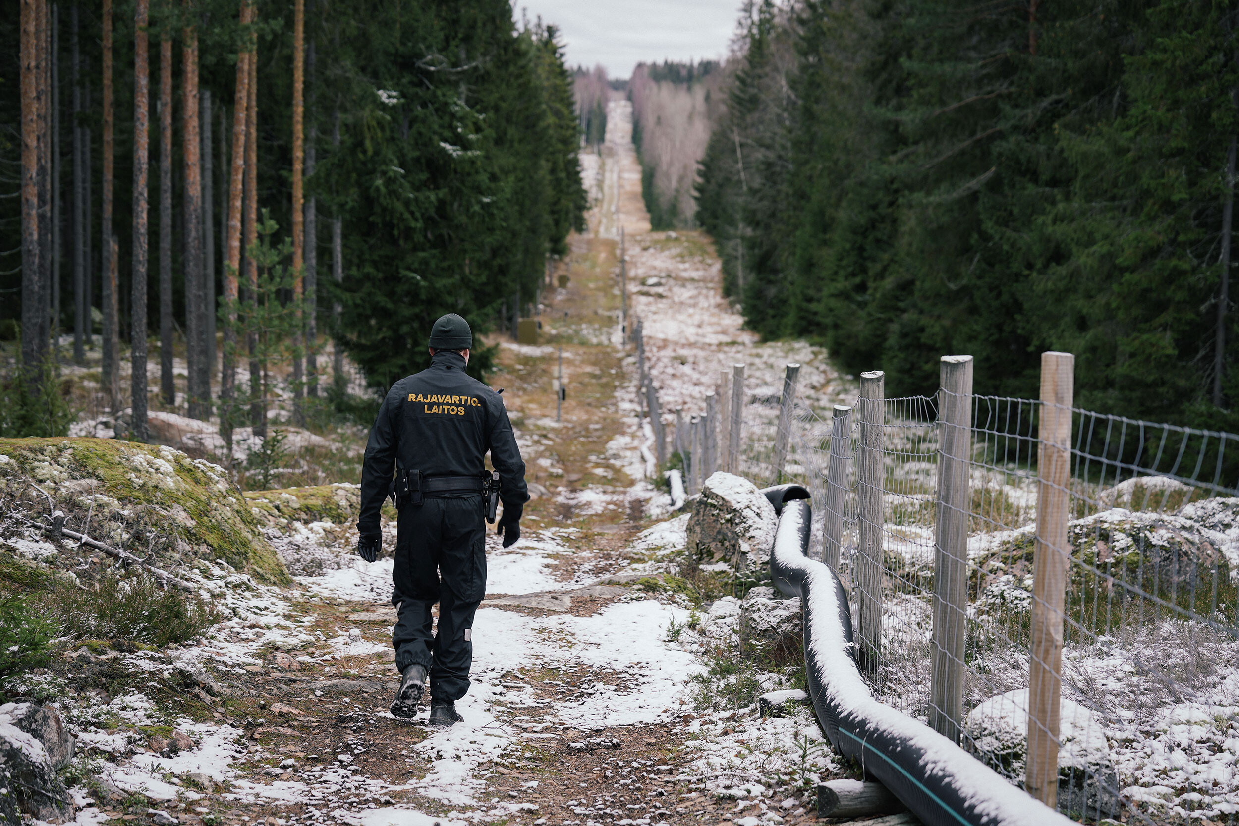 Senior border guard officer Juho Pellinen walks along a fence marking the boundary area between Finland and Russia on Friday. Finland has proposed to spend $143 million on building barrier fences on its eastern border with Russia in 2023.