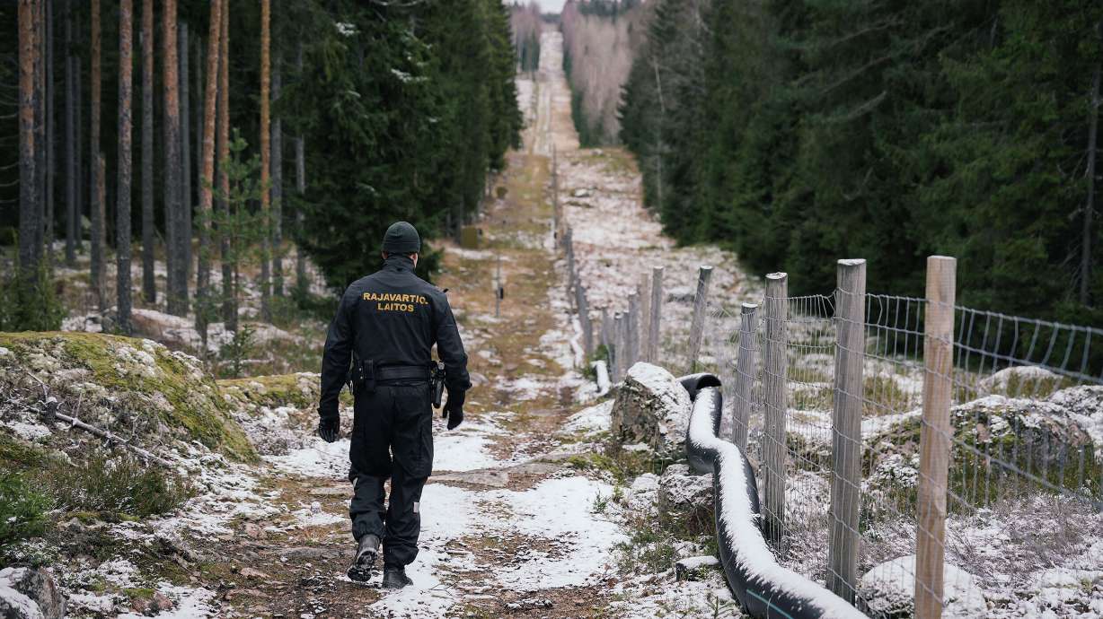 Senior border guard officer Juho Pellinen walks along a fence marking the boundary area between Finland and Russia on Friday. Finland has proposed to spend $143 million on building barrier fences on its eastern border with Russia in 2023.