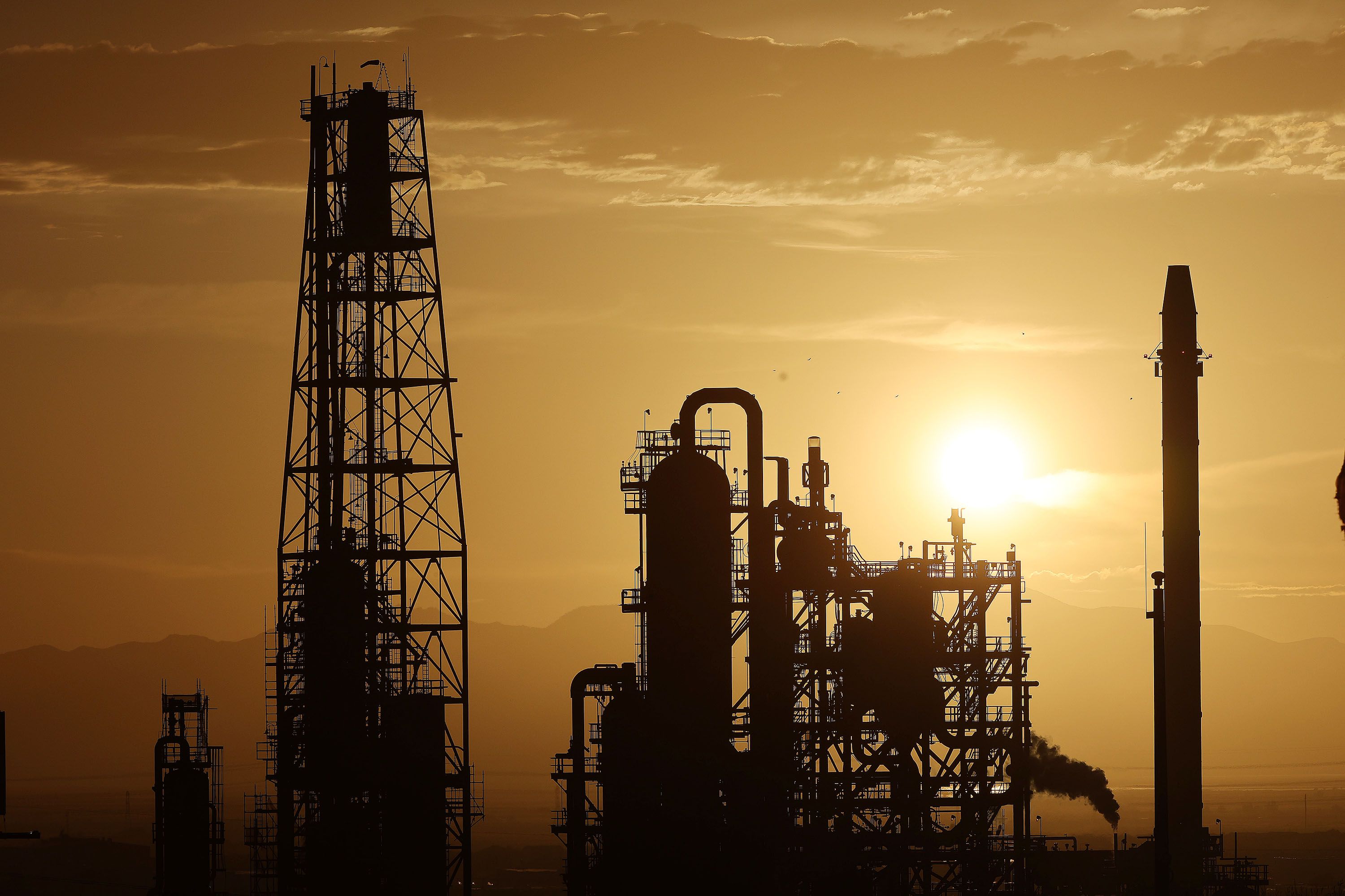 The sun sets behind the Big West Oil LLC refinery in North Salt Lake on June 23.