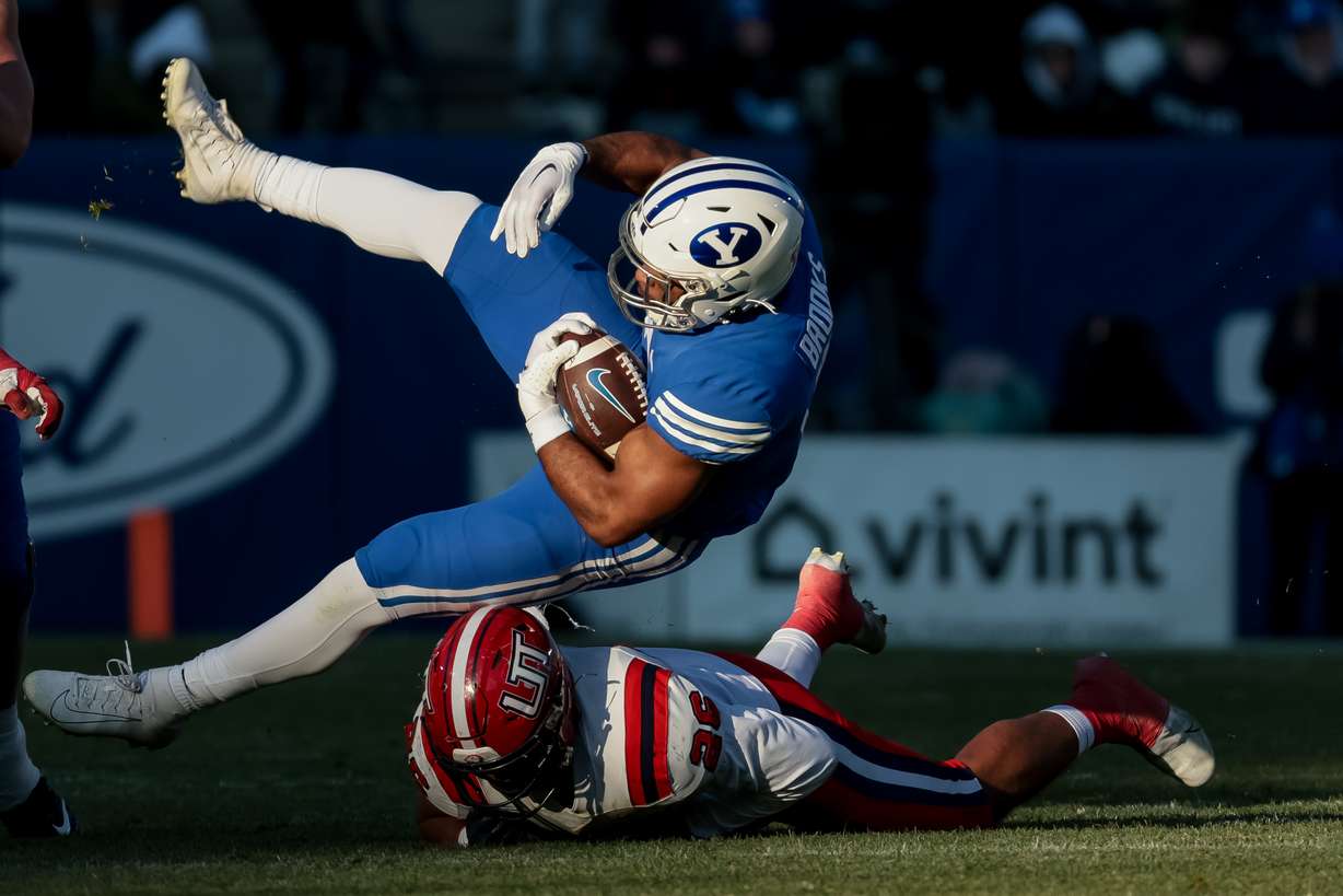 Utah Tech linebacker Kaejin Smith-Bejgrowicz (26) tackles BYU running back Christopher Brooks (2) during the game at LaVell Edwards Stadium in Provo on Saturday, Nov. 19, 2022.