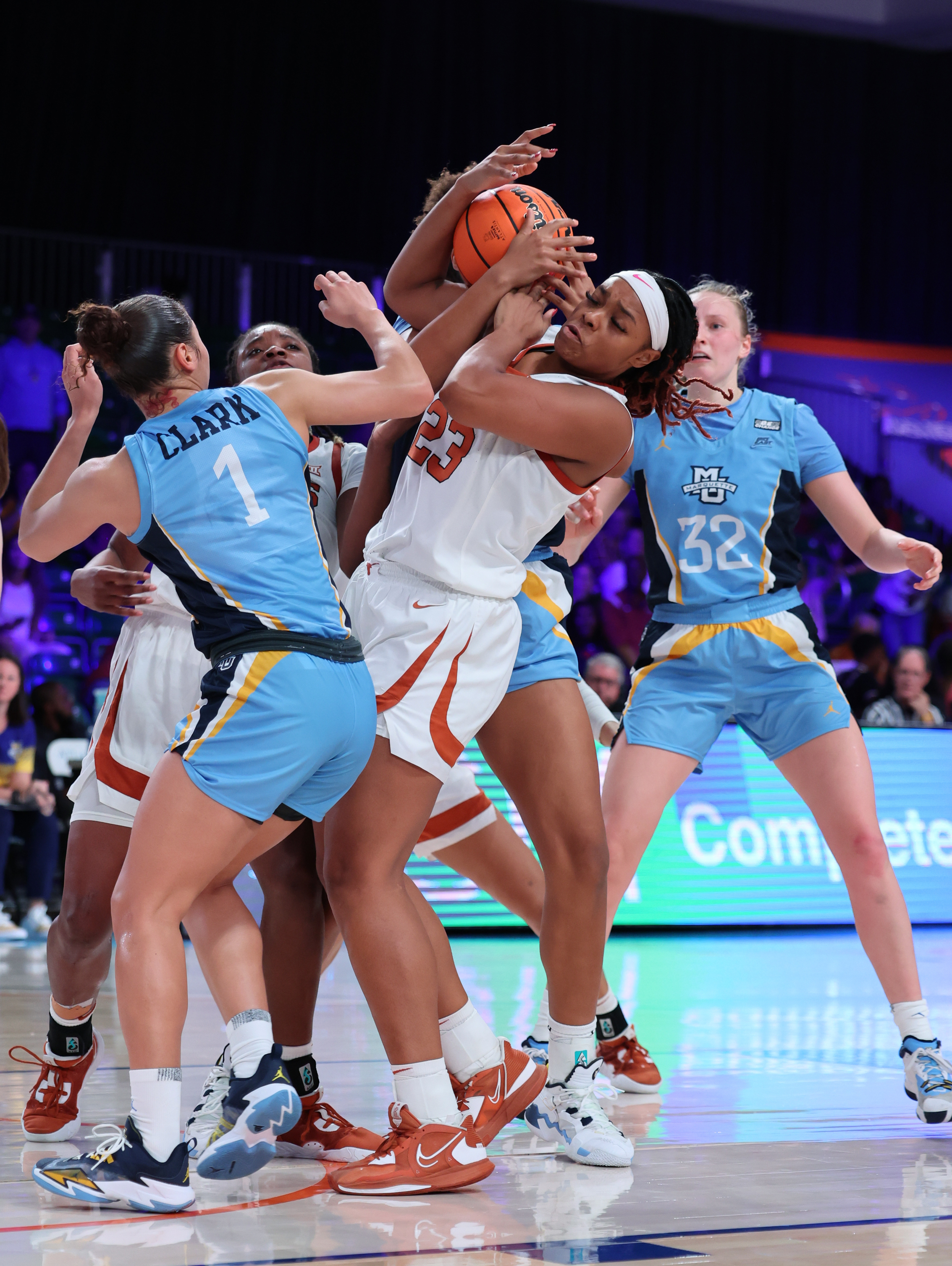 In a photo provided by Bahamas Visual Services, Texas' Aaliyah Moore (23) tries to get possession of the ball next to Marquette's Nia Clark during an NCAA college basketball game at the Battle 4 Atlantis on Saturday, Nov. 19, 2022, at Paradise Island, Bahamas. 