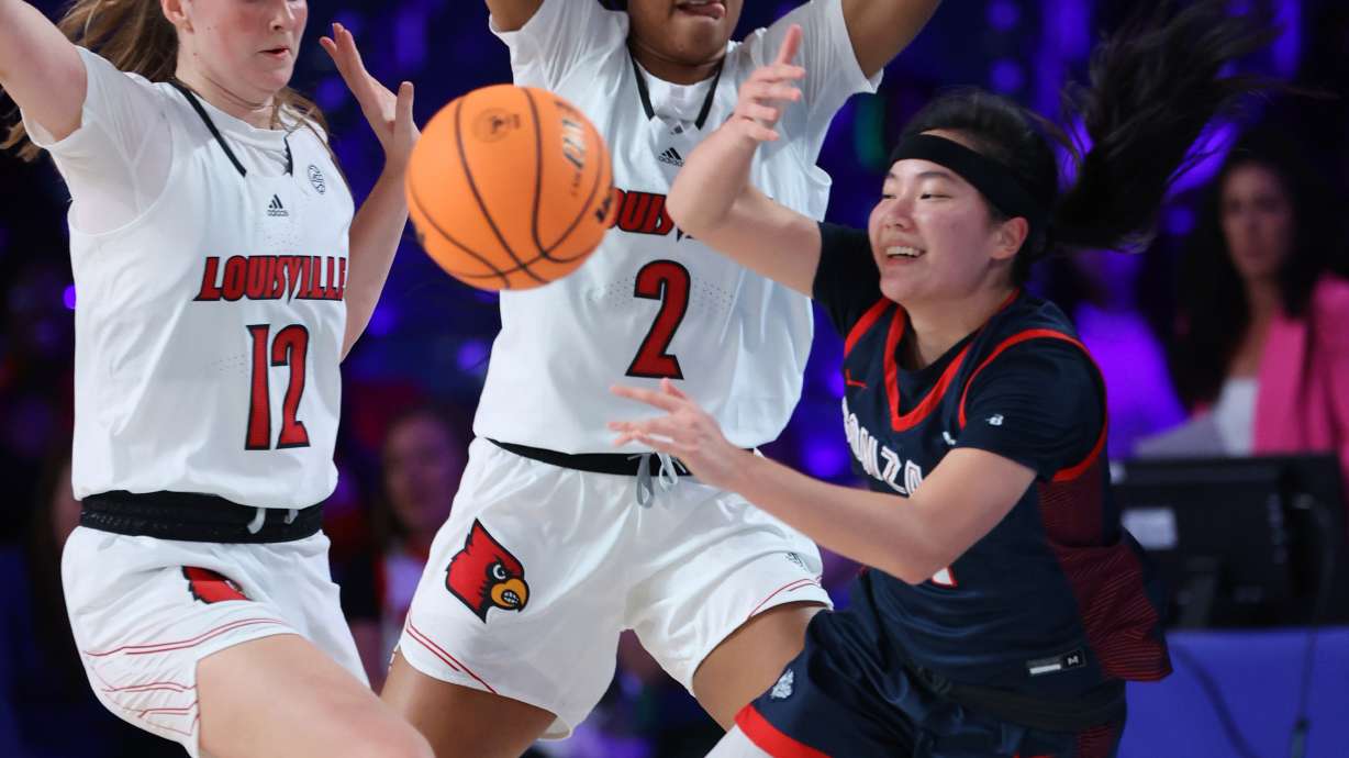 In a photo provided by Bahamas Visual Services, Gonzaga guard Kayleigh Truong, right, is defended by Louisville guard Payton Verhulst, left, and forward Nyla Harris during an NCAA college basketball game in the Battle 4 Atlantis at Paradise Island, Bahamas, Saturday, Nov. 19, 2022.