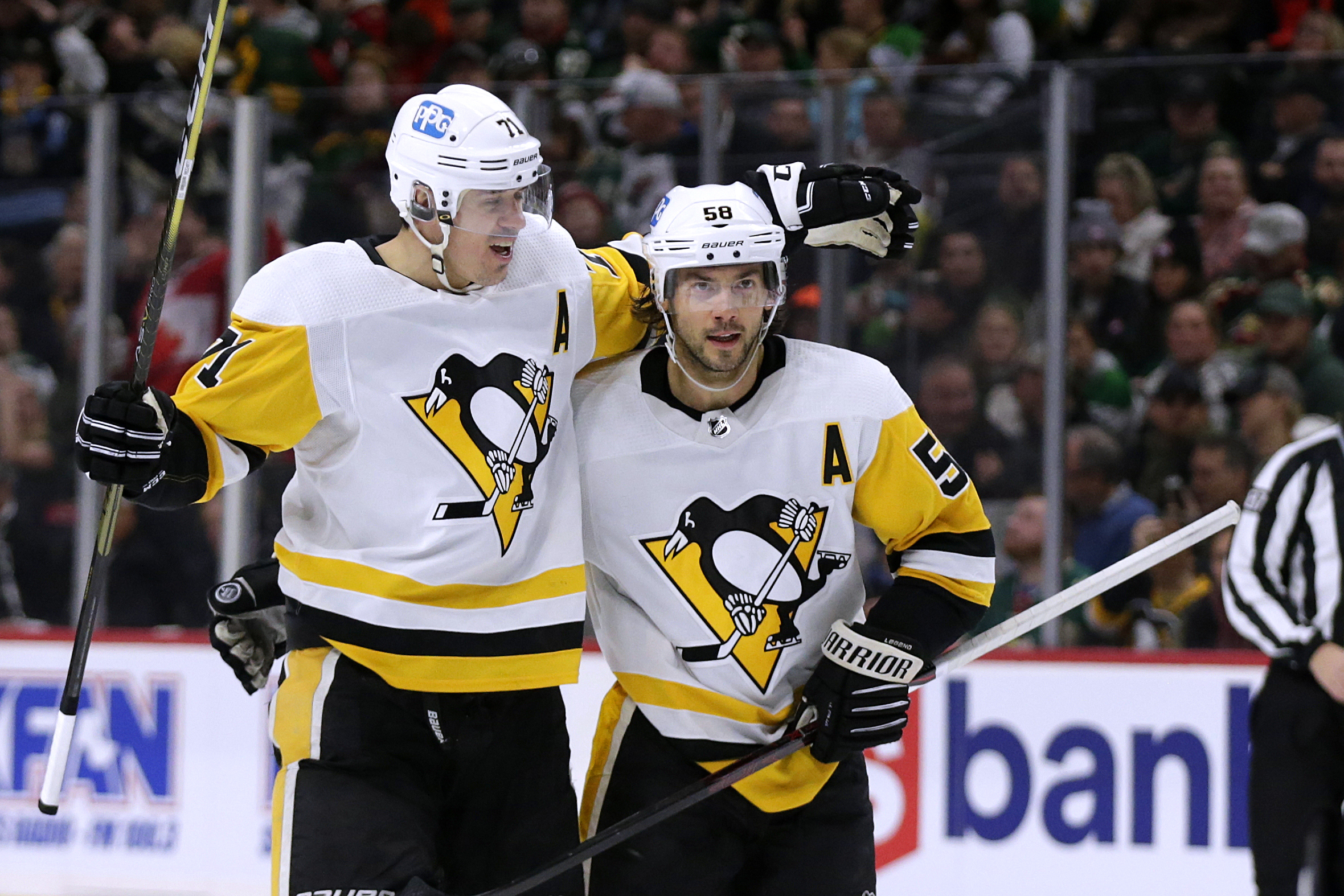 Pittsburgh Penguins defenseman Kris Letang (58) is congratulated by Evgeni Malkin (71) after scoring a goal against the Minnesota Wild during the second period of an NHL hockey game Thursday, Nov. 17, 2022, in St. Paul, Minn. 