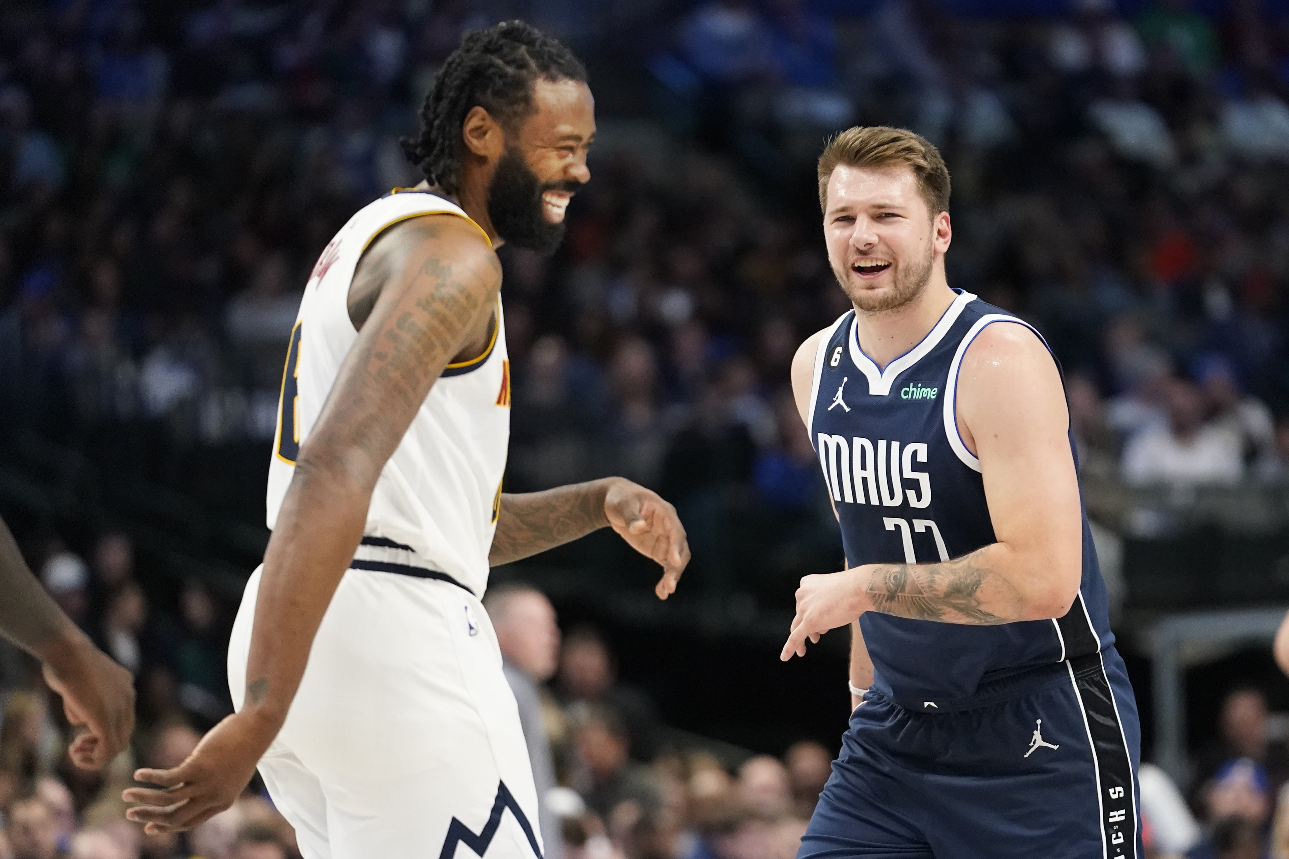 Denver Nuggets center DeAndre Jordan (6) and Dallas Mavericks guard Luka Doncic (77) laugh after they bumped into each other during the first quarter of an NBA basketball game in Dallas, Sunday, Nov. 20, 2022. 